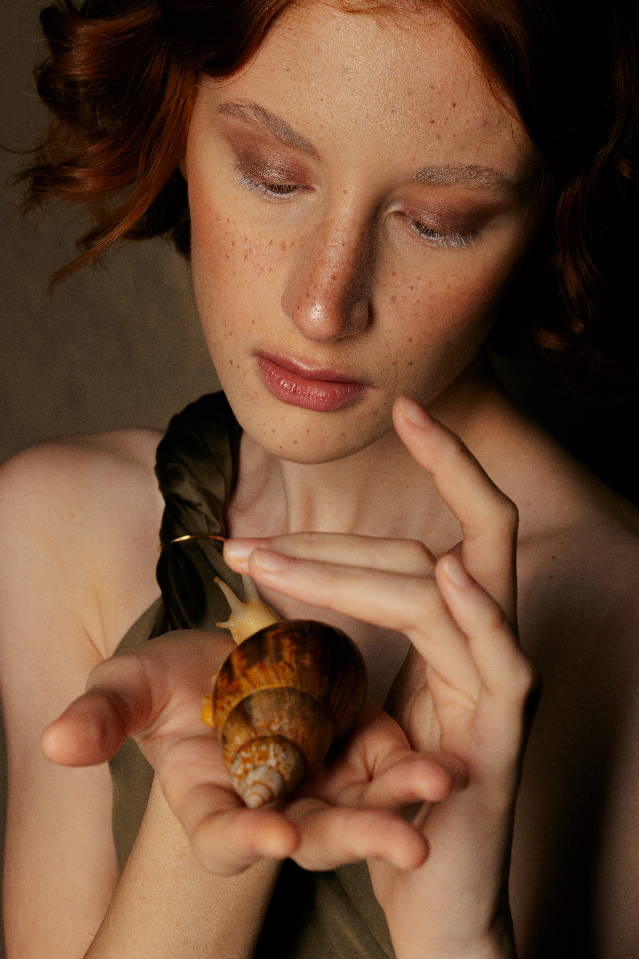 девушка нежно гладит по панцирю улитку Ахатину, которую держит на ладошке