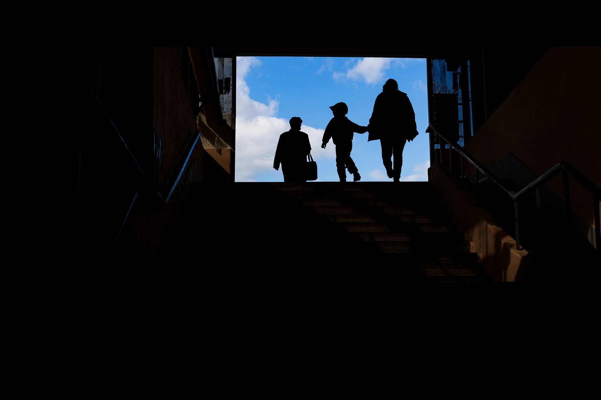 Силуэт мамы с мальчиком выходящего из подземного перехода