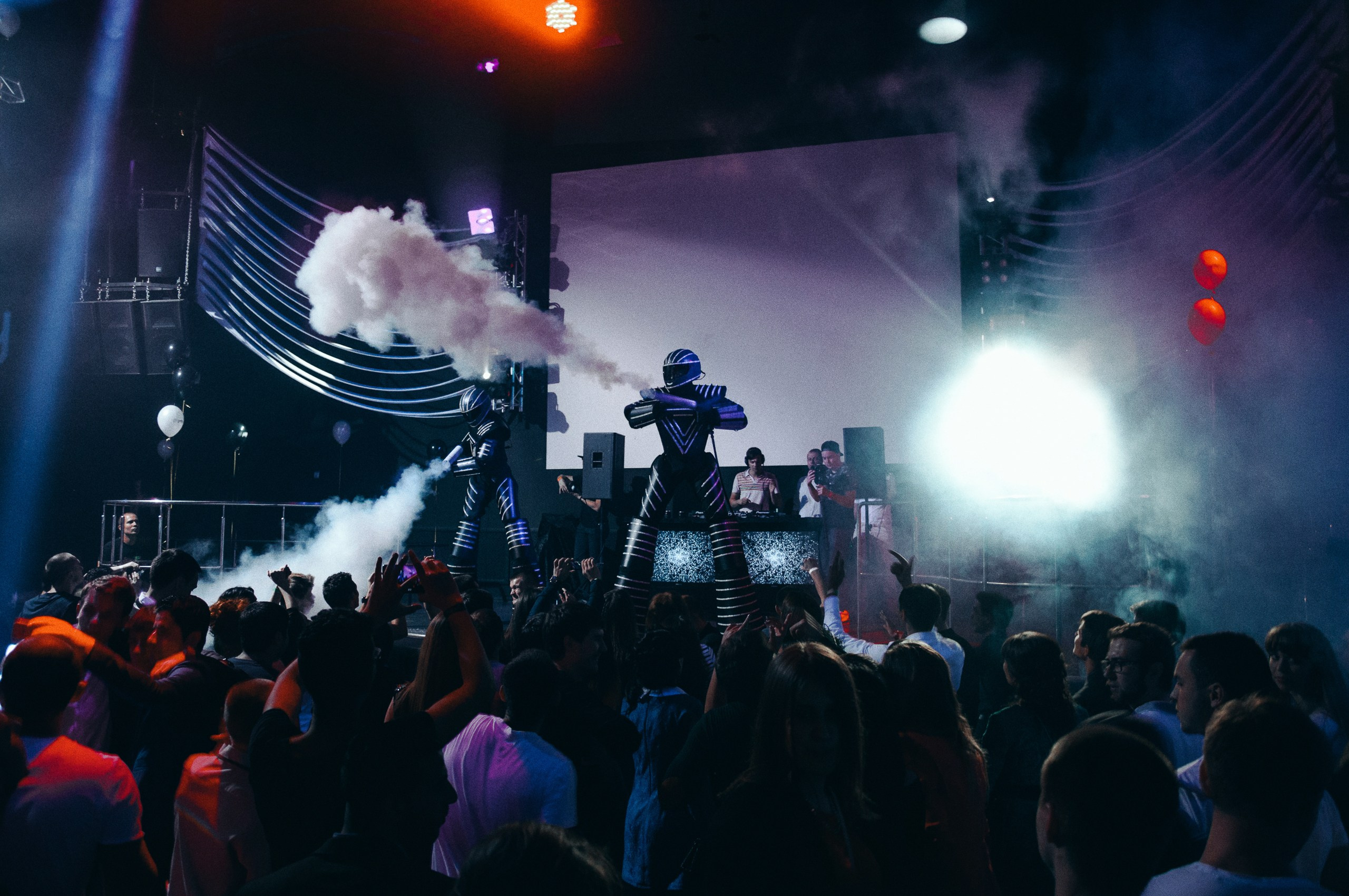 Репортажная съемка вечеринки – танцующие гости на ярко освещенной сцене.