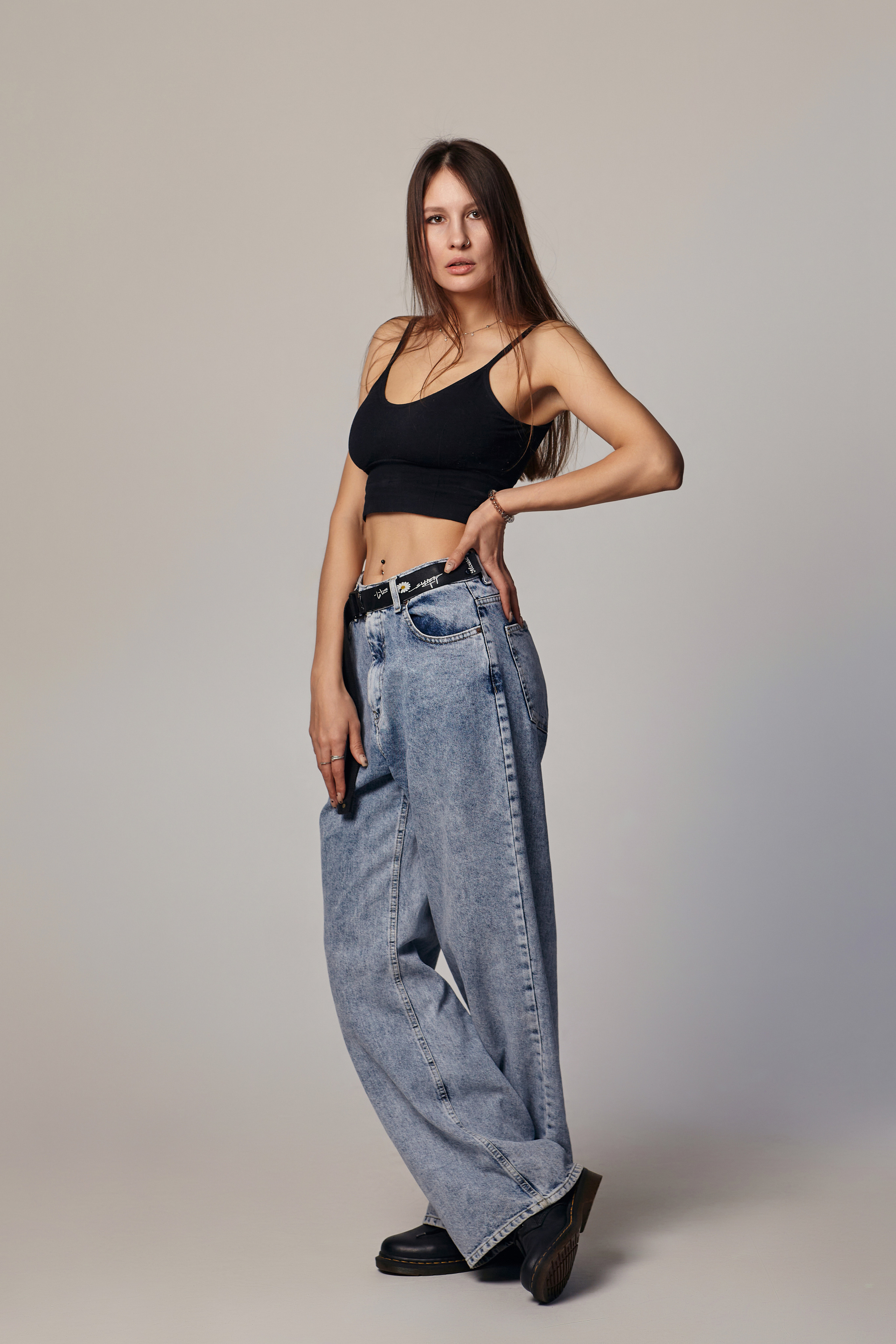 Девушка с темными волосами в студии на светлом фоне