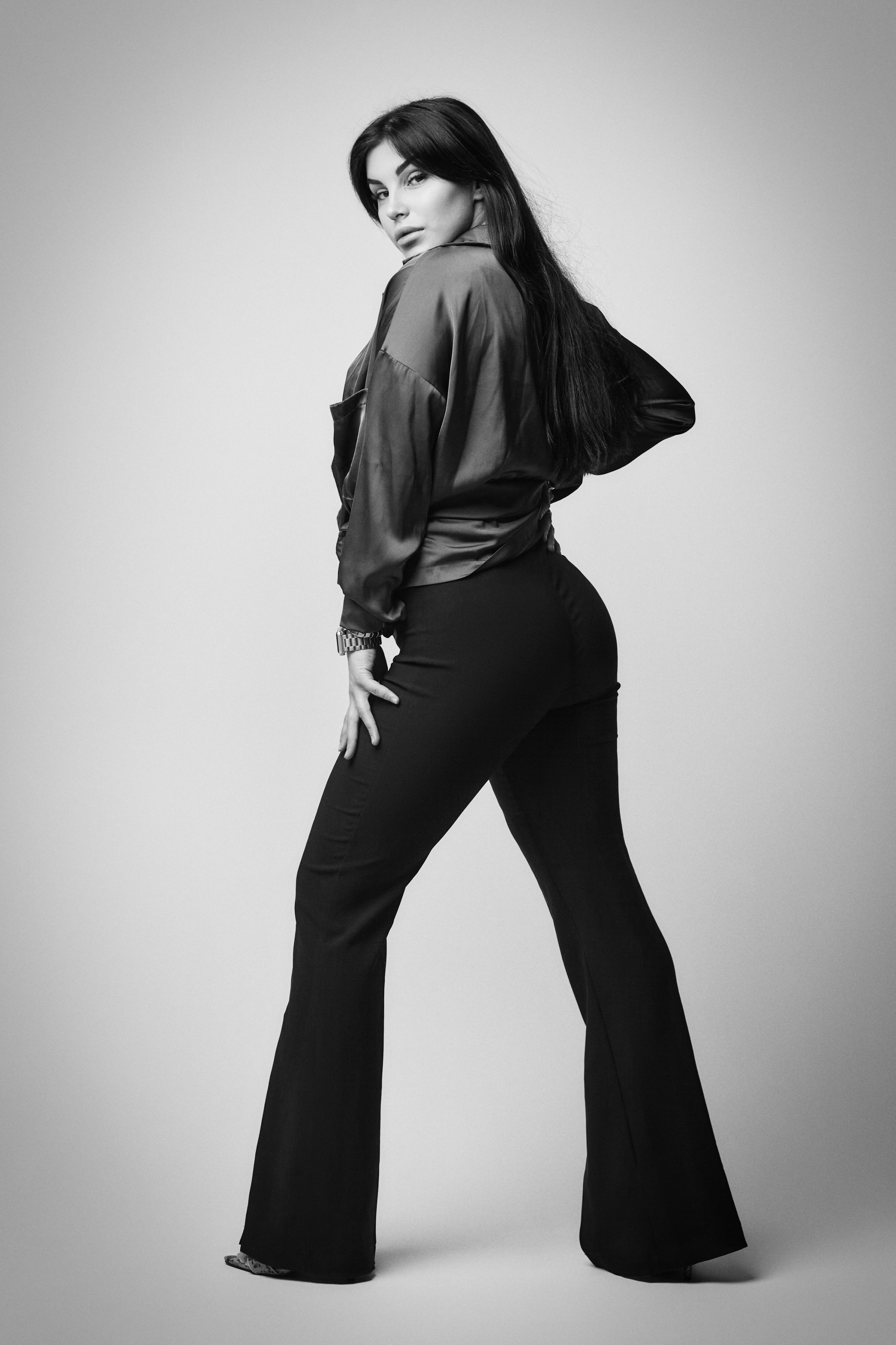 Темноволосая Карина в студии на светлом фоне: элегантно и стильно в костюме, рубашке или платье