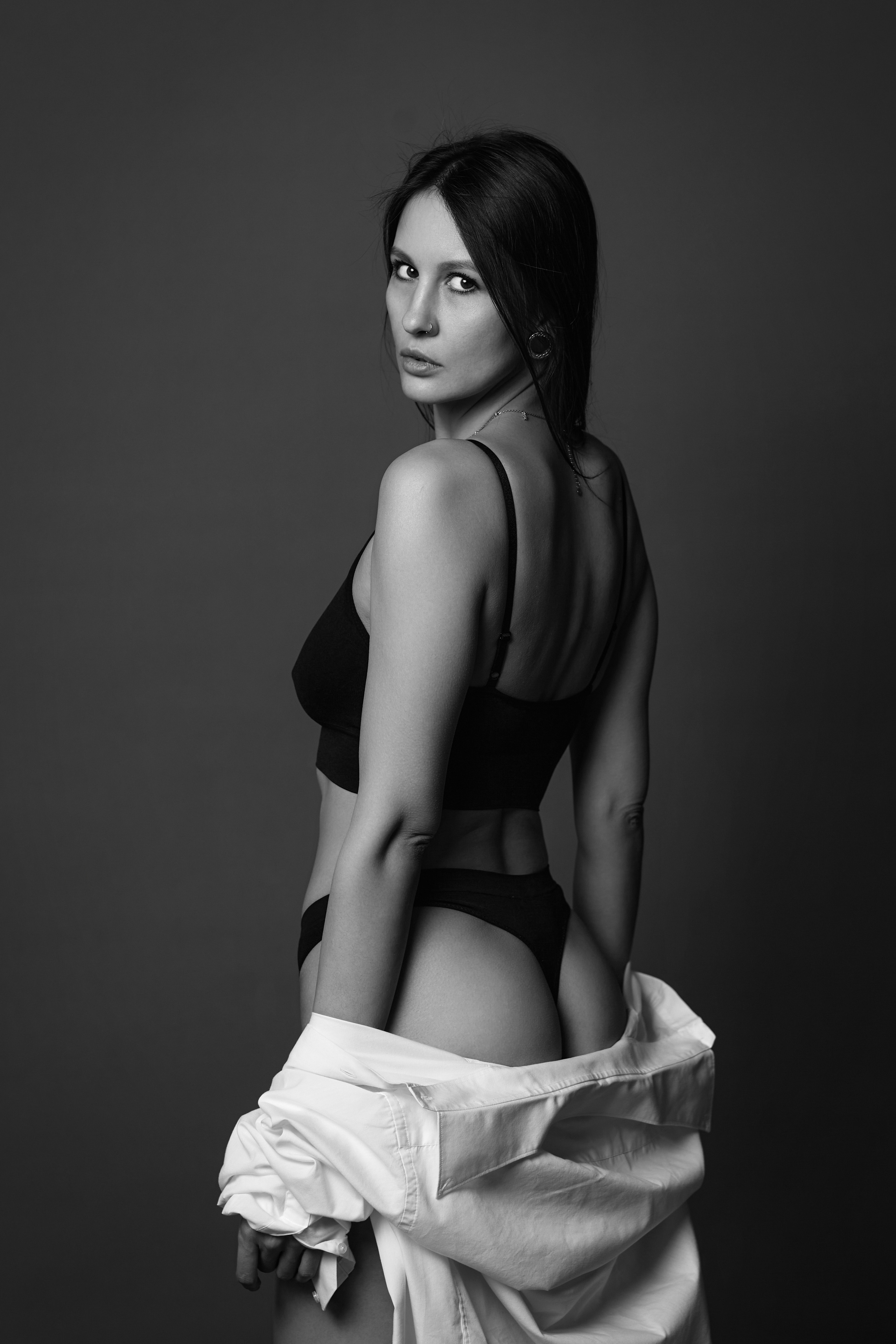 Темноволосая модель на циклораме в светлых тонах.