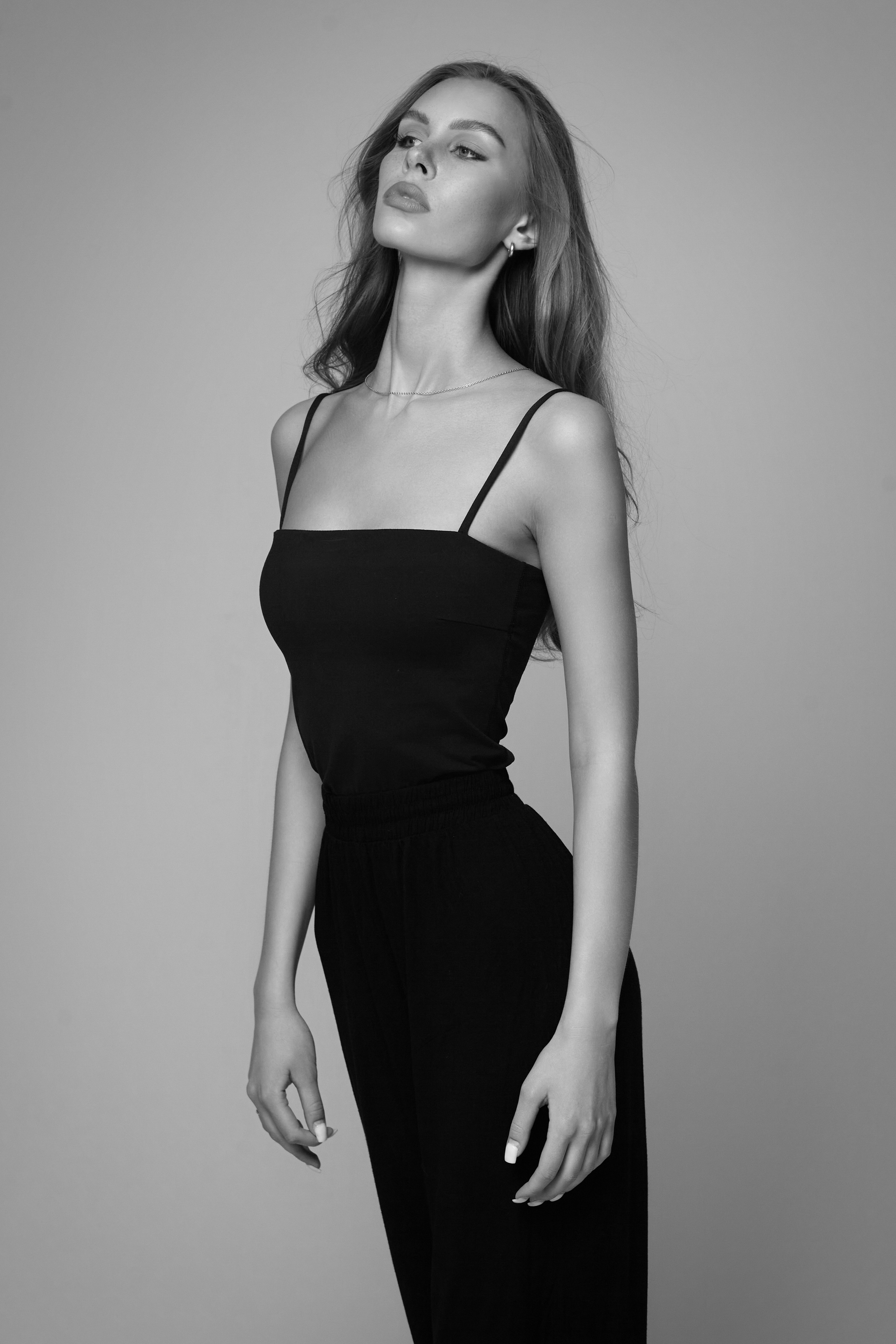 Девушка с очками на светлом фоне фотостудии.