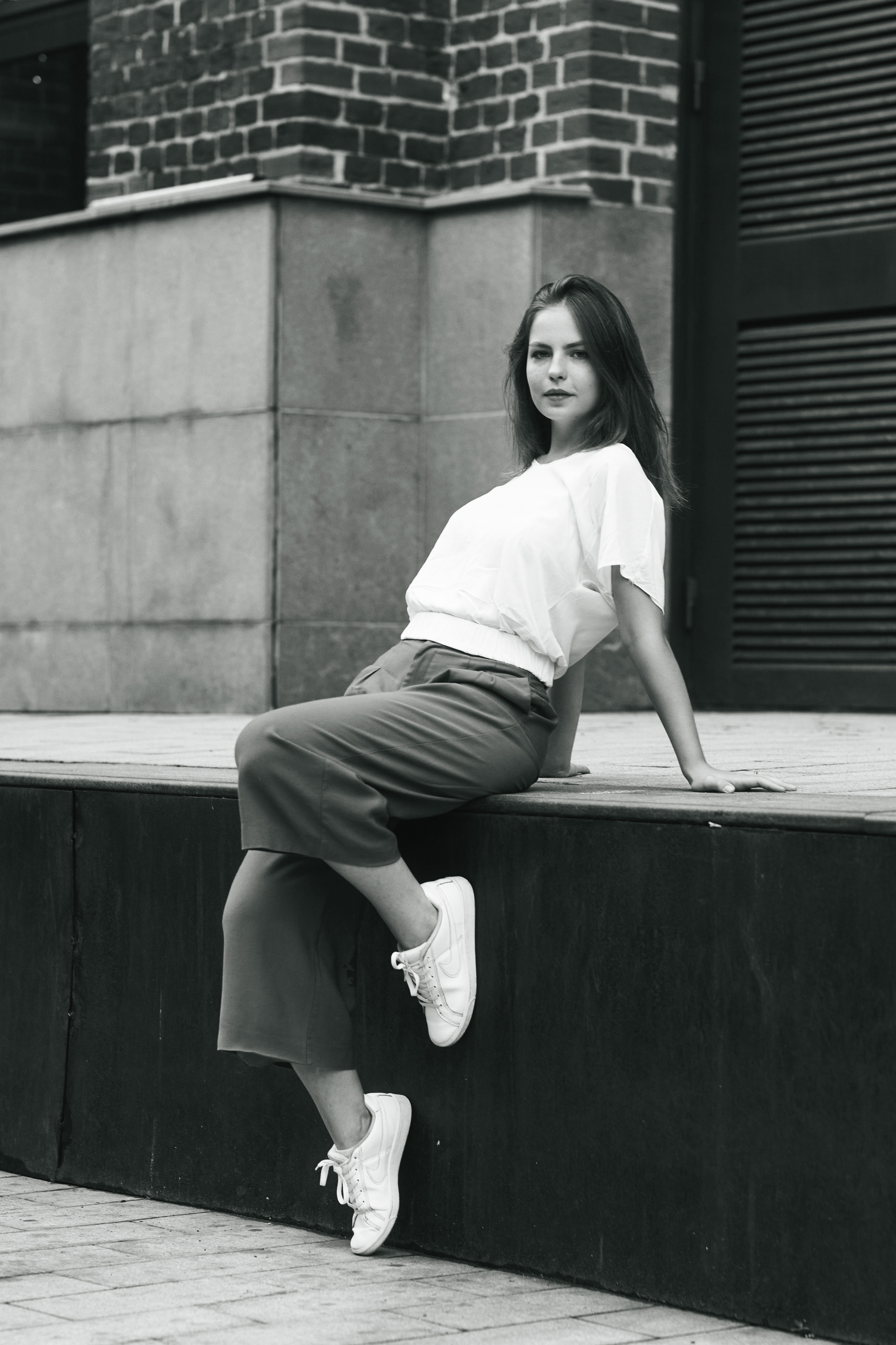 Дарья позирует на улице Москвы в светлой кофте и широких брюках.