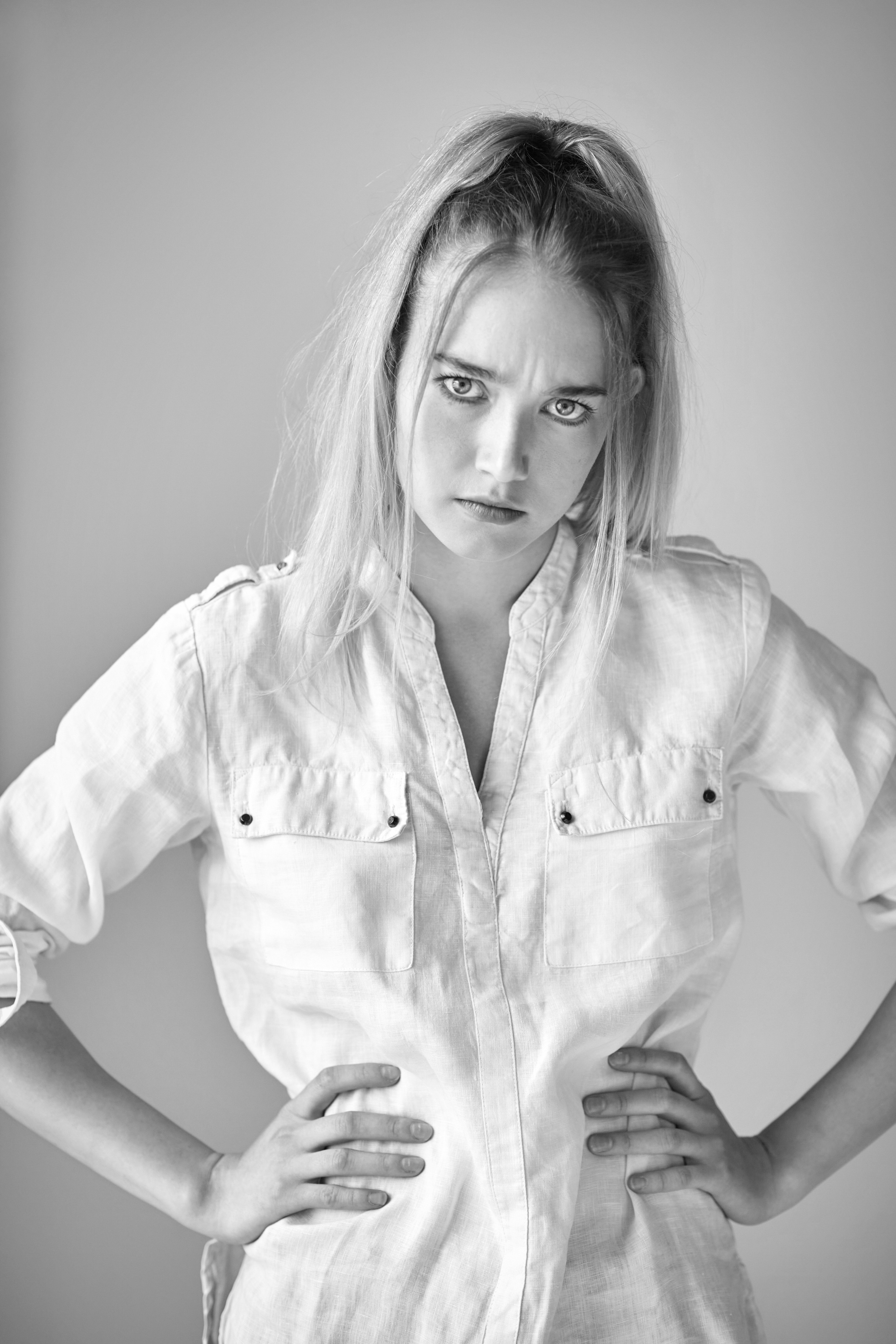 Светловолосая модель Алиса в легком белом платье на светлом фоне студии - нежность и женственность.