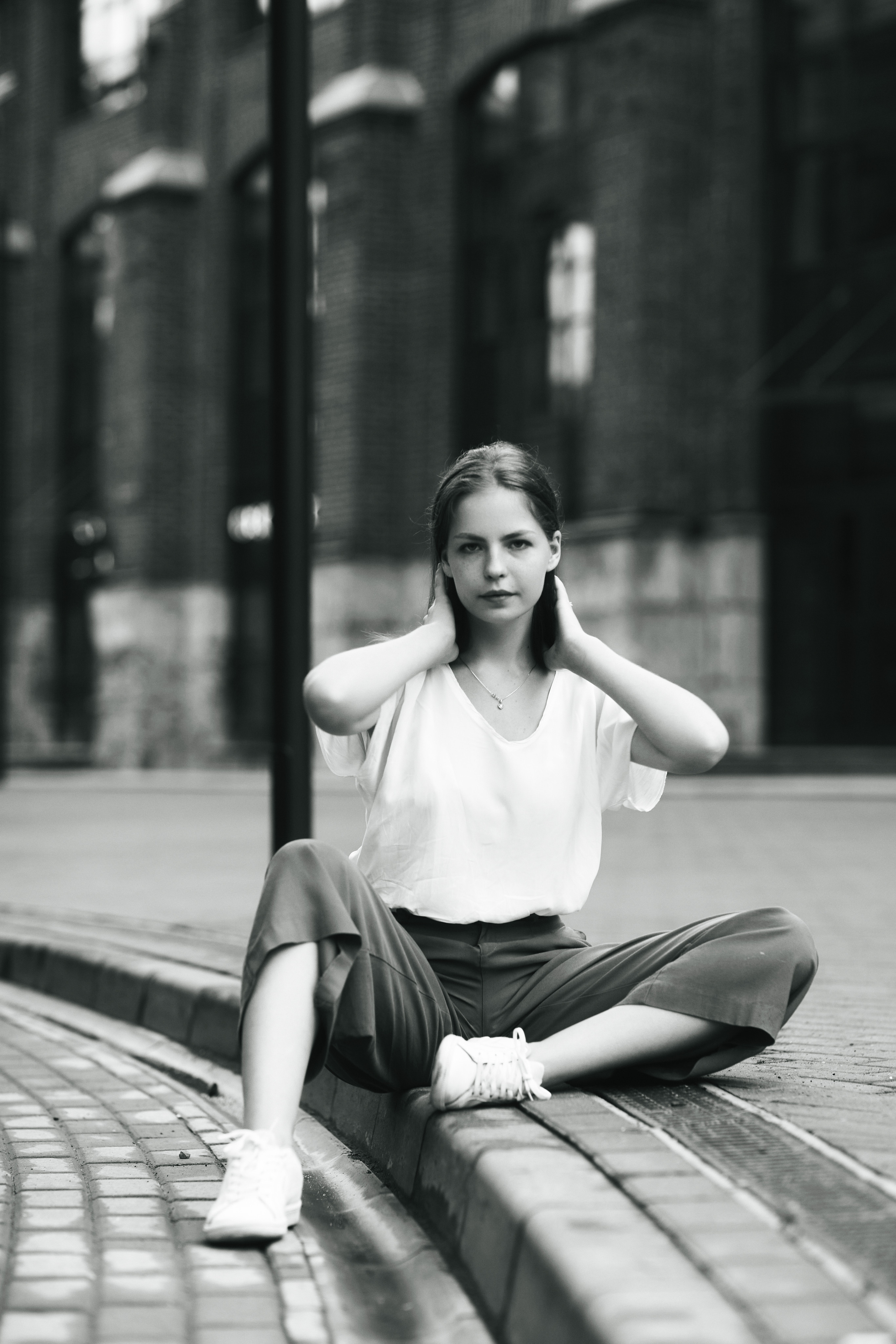 Модель с темными волосами, Дарья, на улице Москвы в светлой кофте и широких брюках.