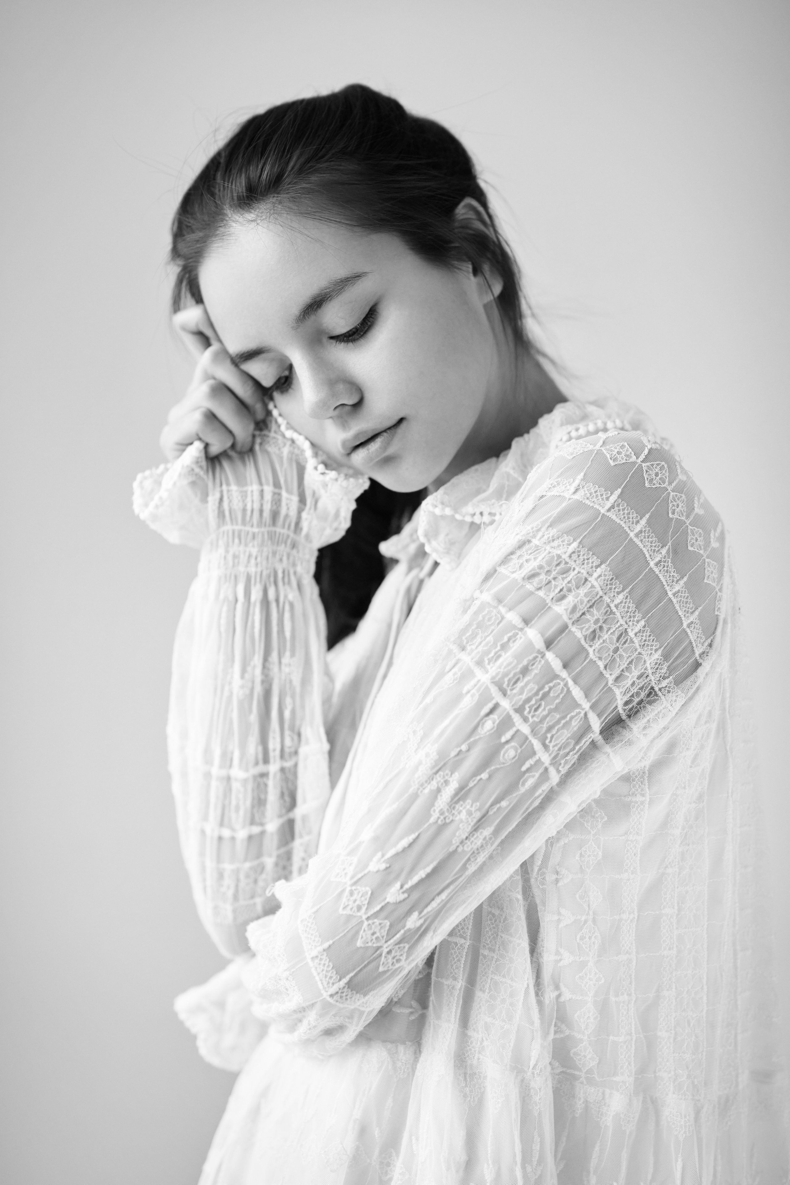 В студии на светлом фоне темноволосая модель Амина предстает в светлом топике, подчеркивающем ее стройные формы.