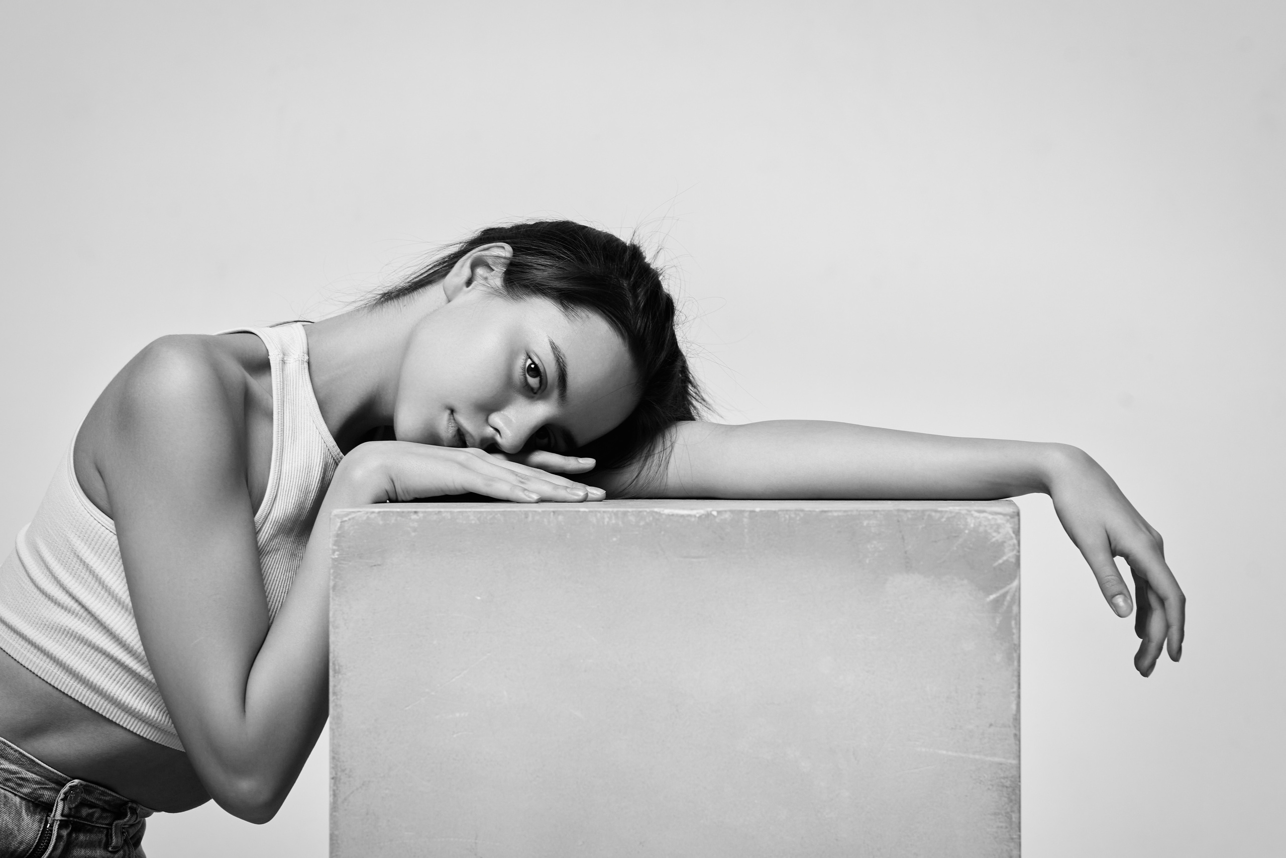 Амина в светлом наряде на фоне студии, производящая яркое впечатление.