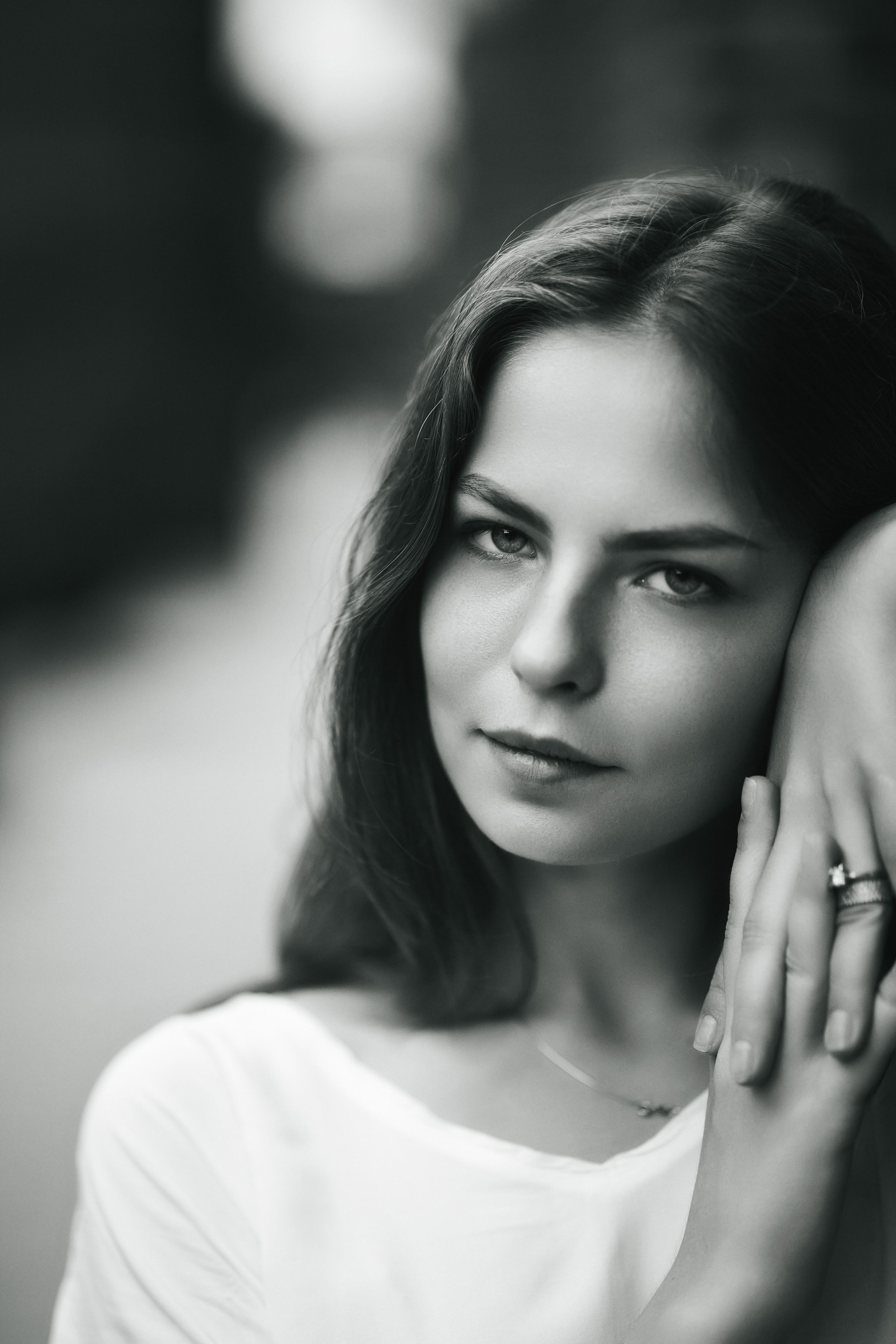 Дарья, модель с темными волосами, позирует на улице Москвы в светлой кофте и широких брюках.