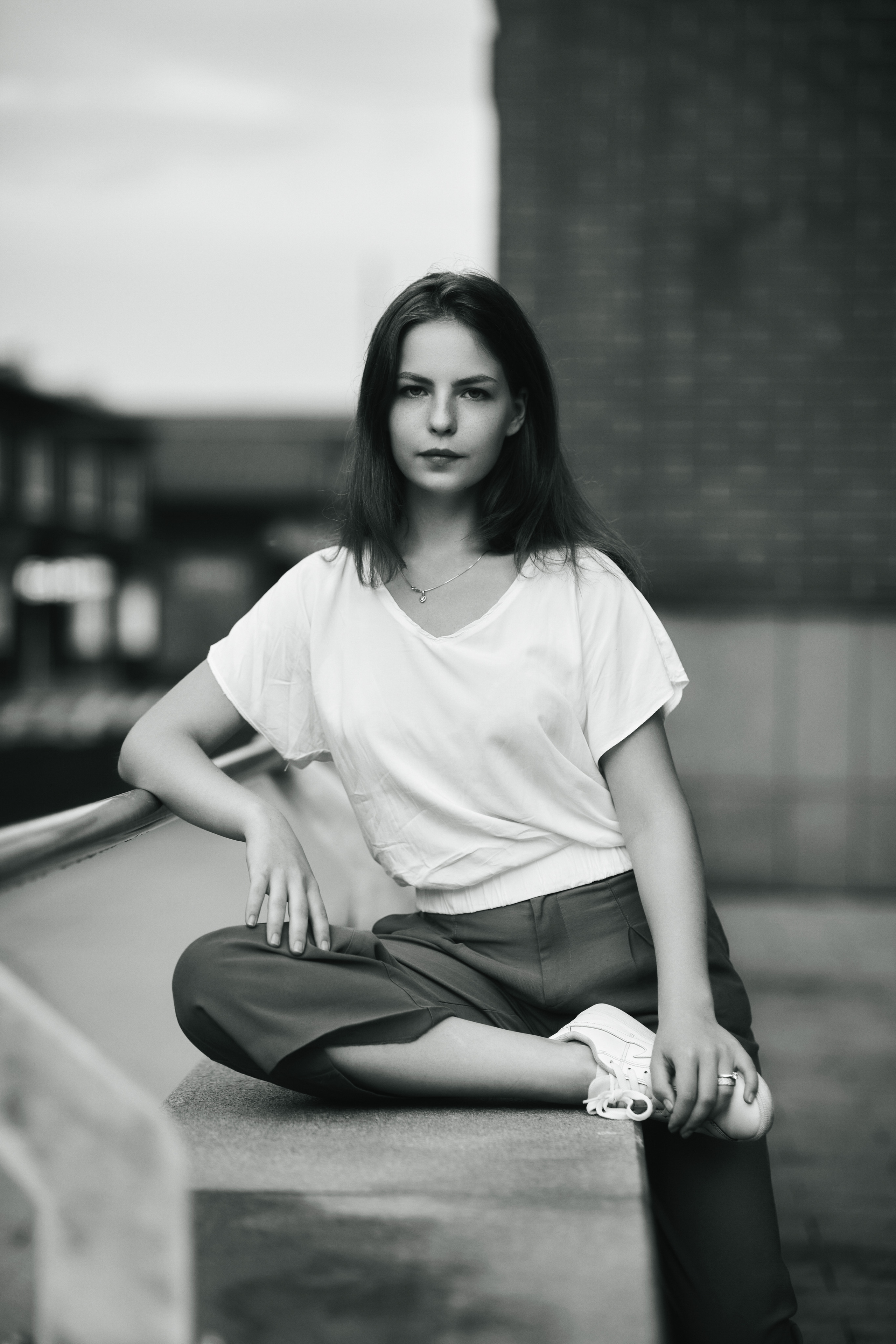 Модель Дарья на фоне московской улицы в светлой кофте и с темными волосами