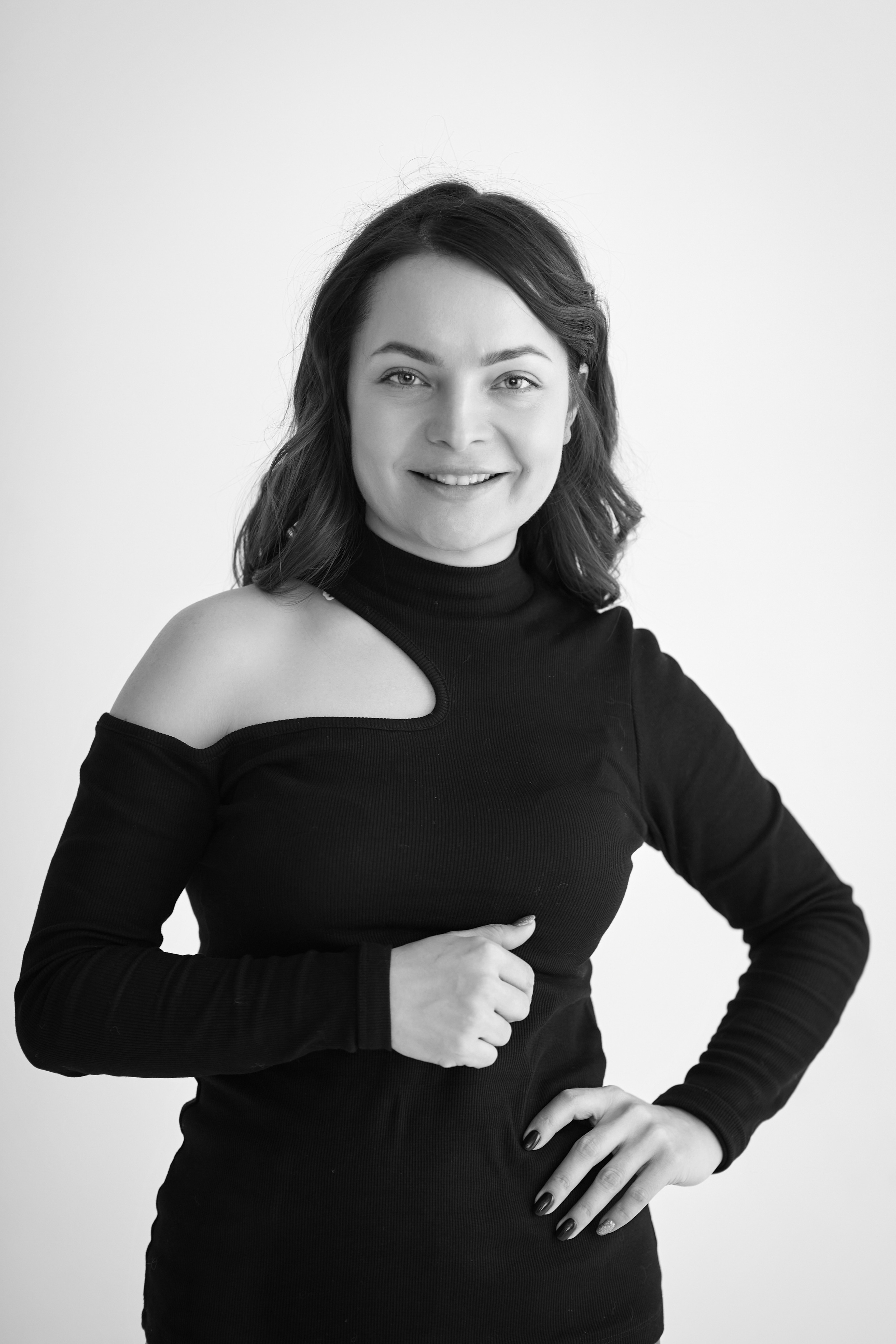 Сидя на стуле в студии на светлом фоне, модель Татьяна одета в рубашку.