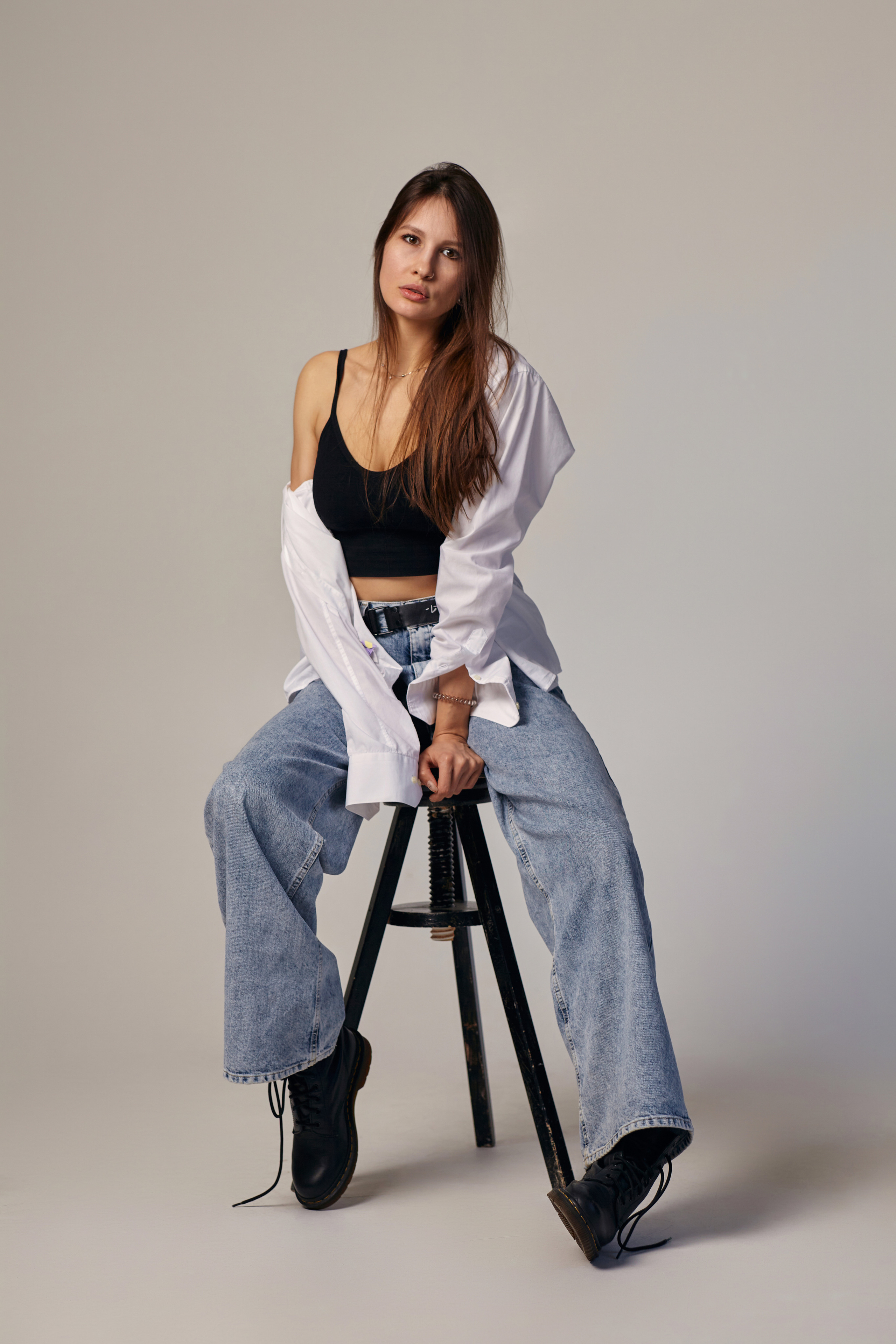 Модель с темными волосами на темном фоне в студии с яркой подсветкой