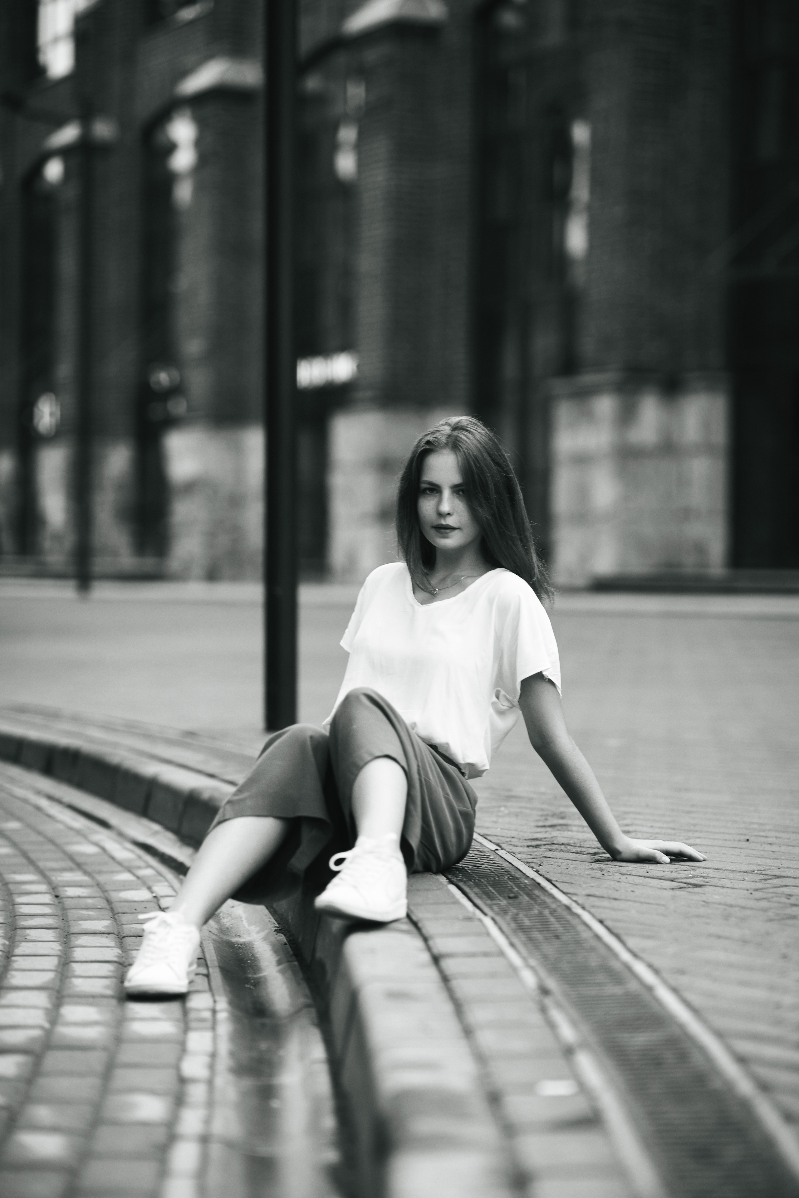 Дарья в светлой кофте и широких брюках на улице города Москвы.