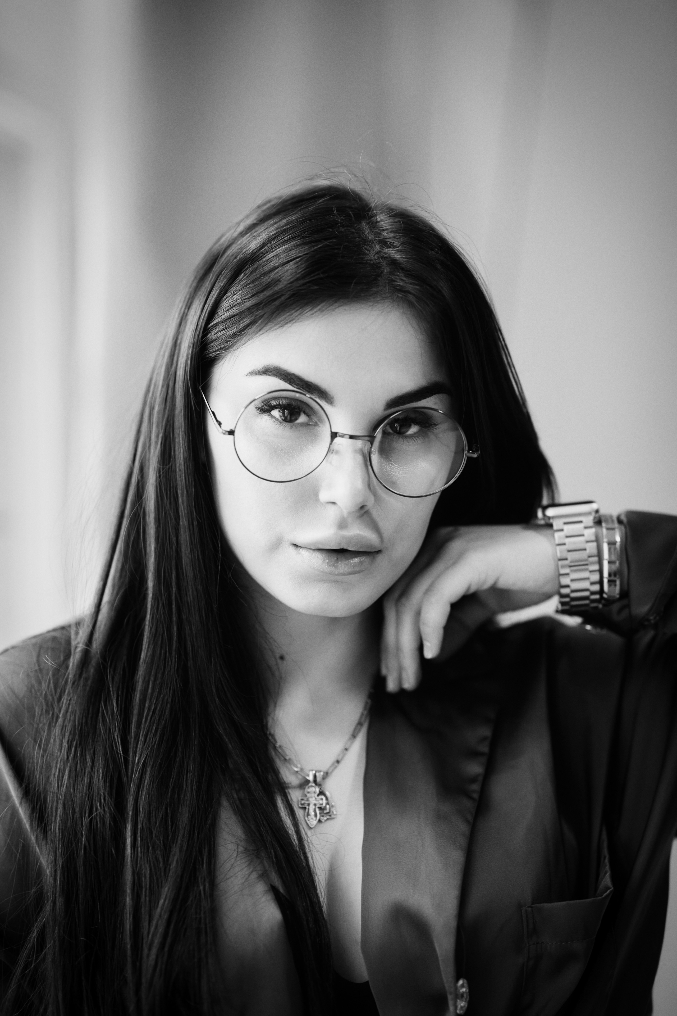 Темноволосая модель Карина в черном костюме на светлом фоне