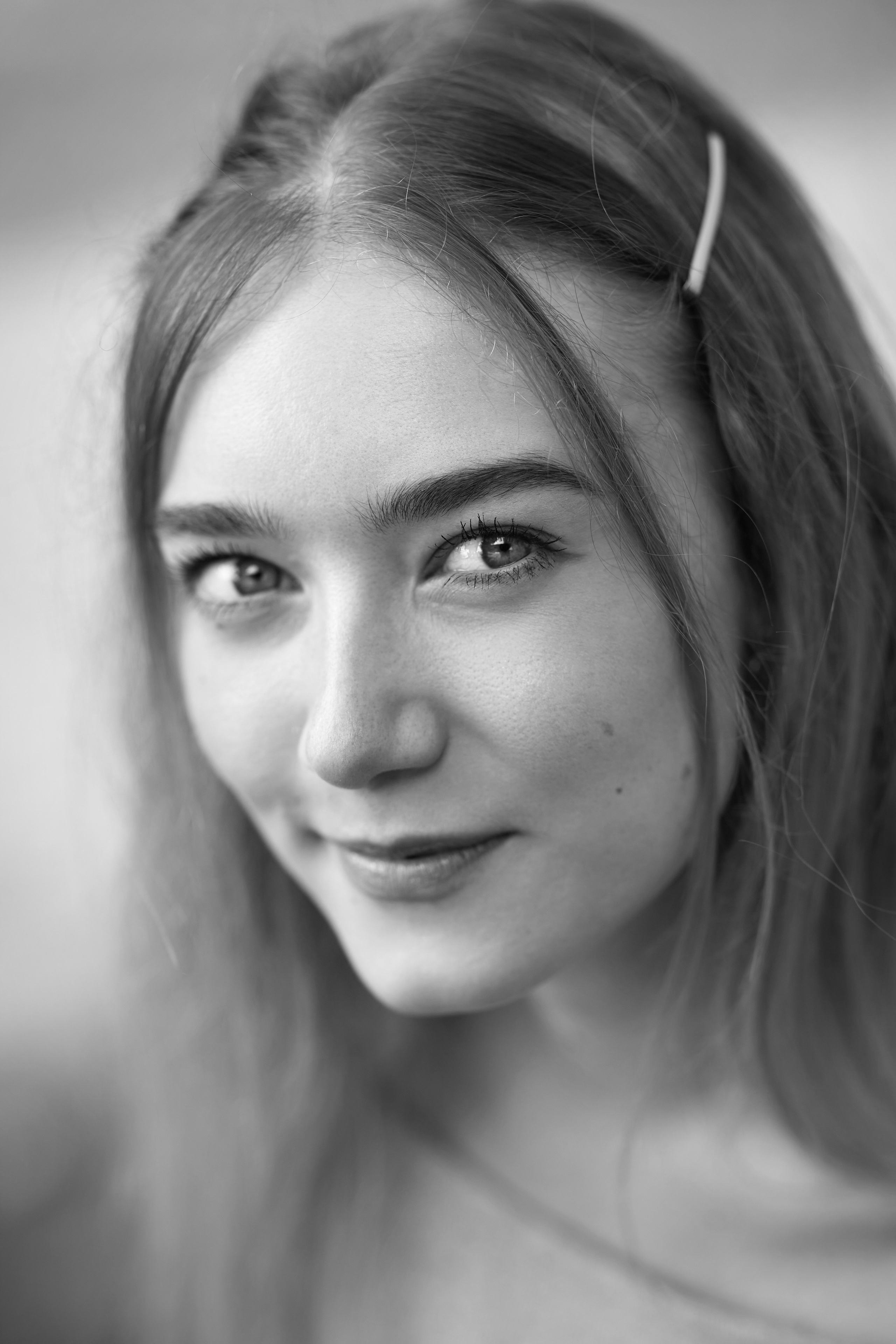 Светловолосая красавица Алиса в белом платье на светлом фоне студии, создает атмосферу чистоты и свежести.