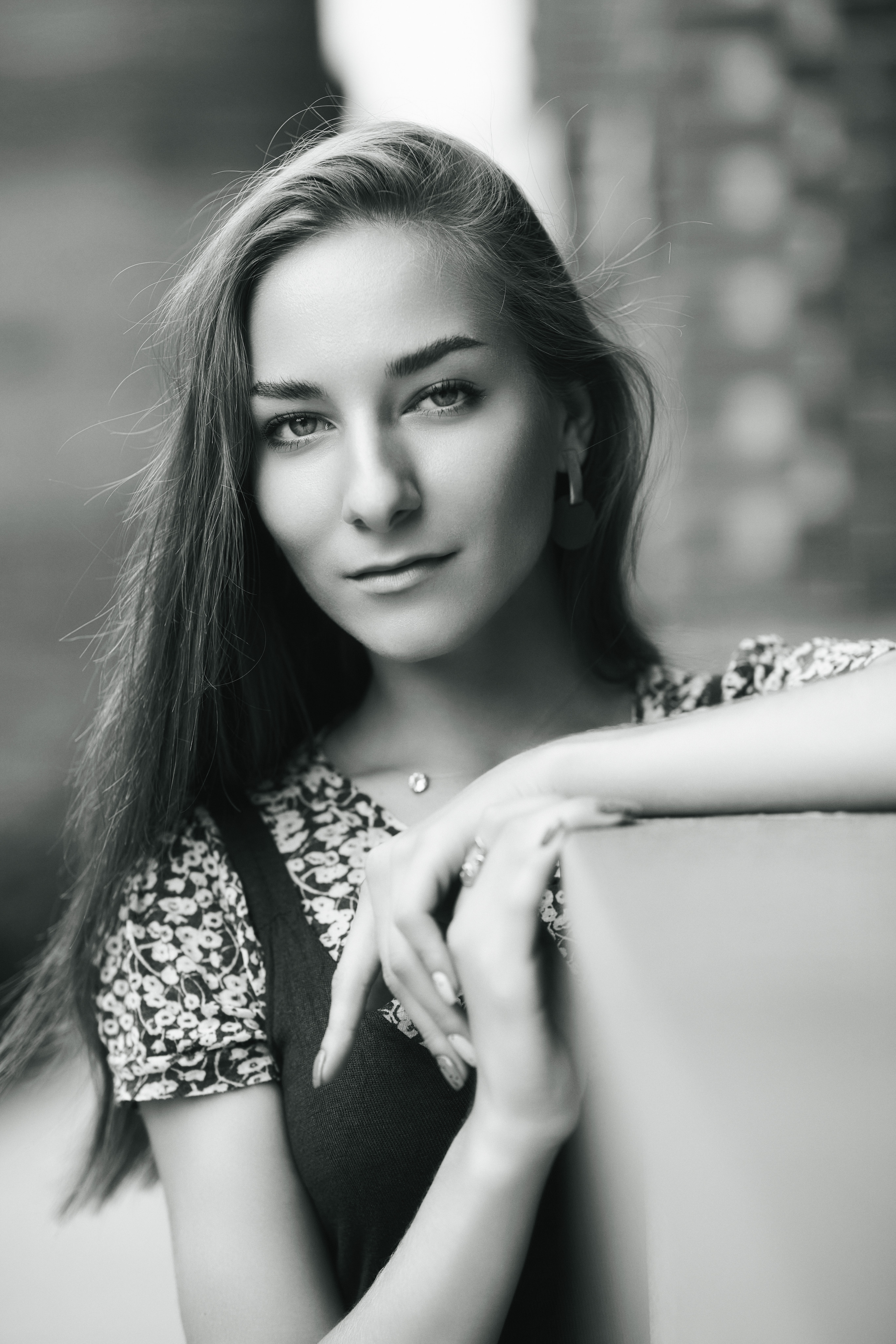 Темноволосая Любовь на фоне городского пейзажа в стильном платье или удобных джинсах.