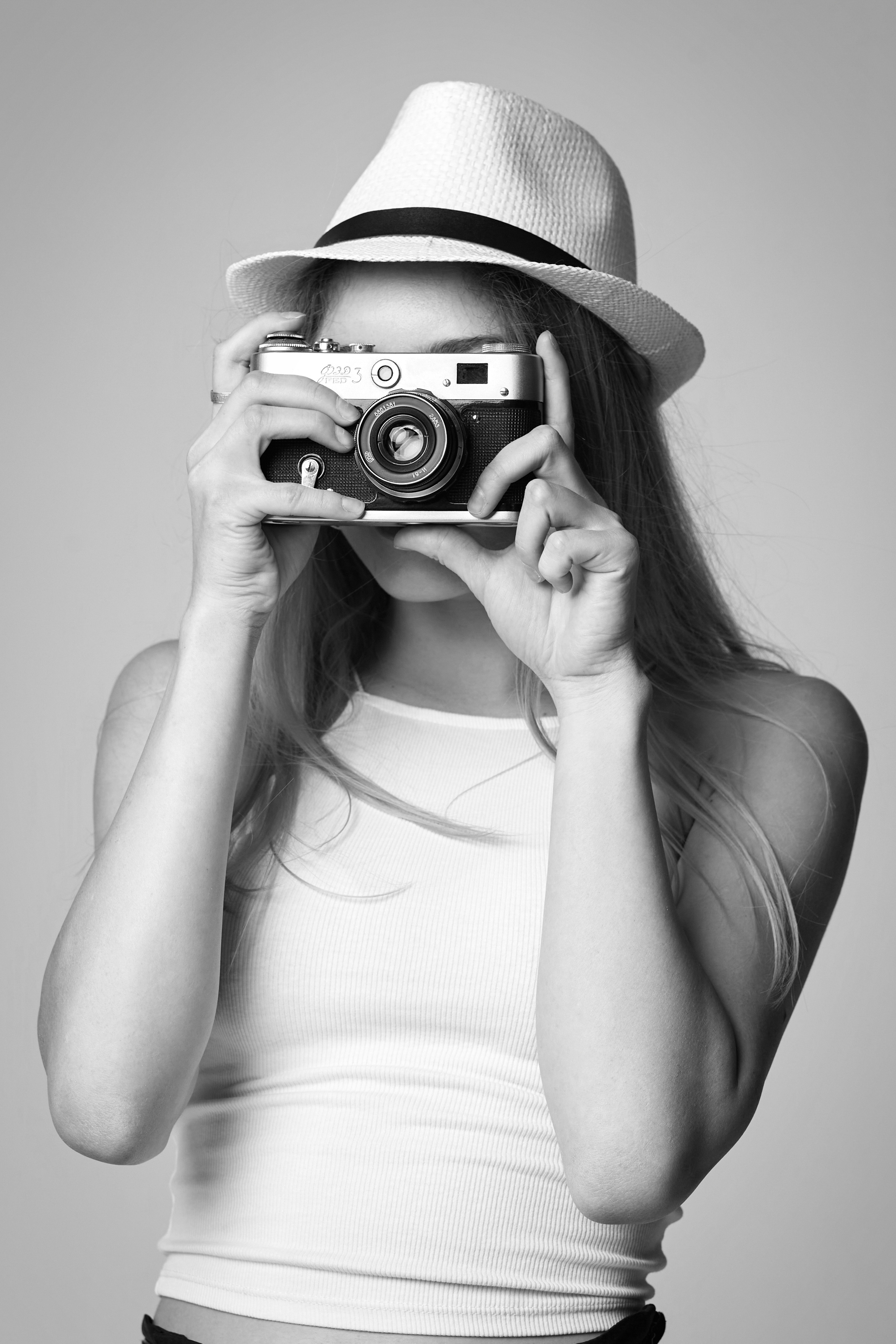 Светловолосая модель в студии на светлом фоне в свободном платье с цветочным принтом.