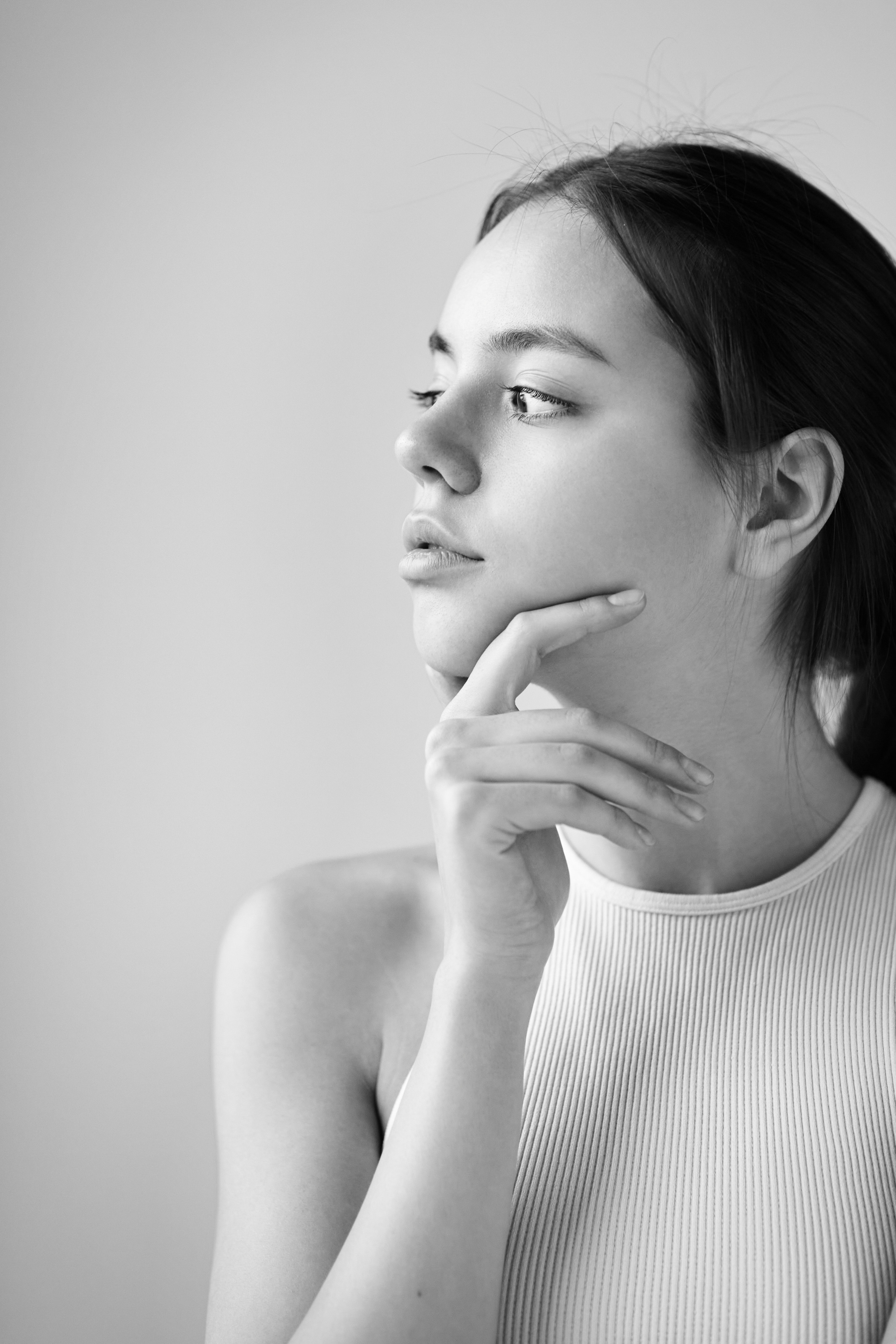 Модель Амина в студии на светлом фоне в светлом топике и приятной улыбке