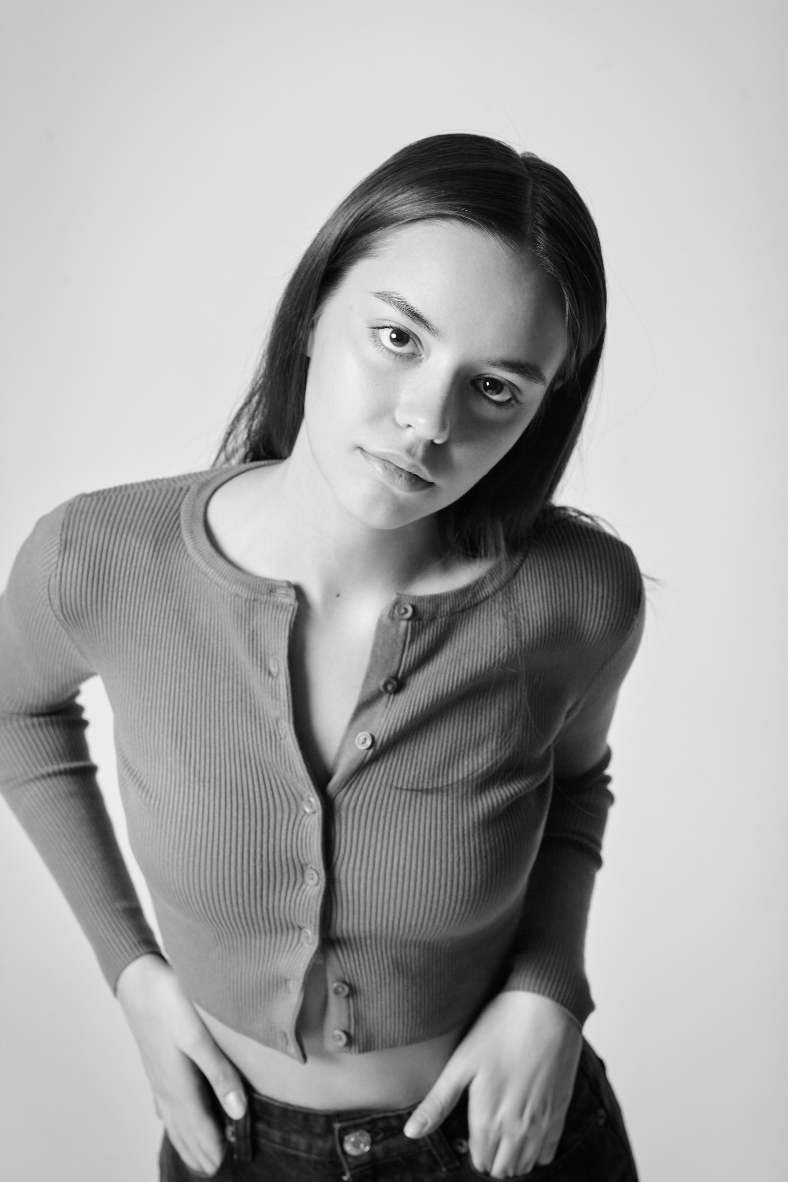 Темноволосая модель Амина в светлом платье или топике на светлом фоне.