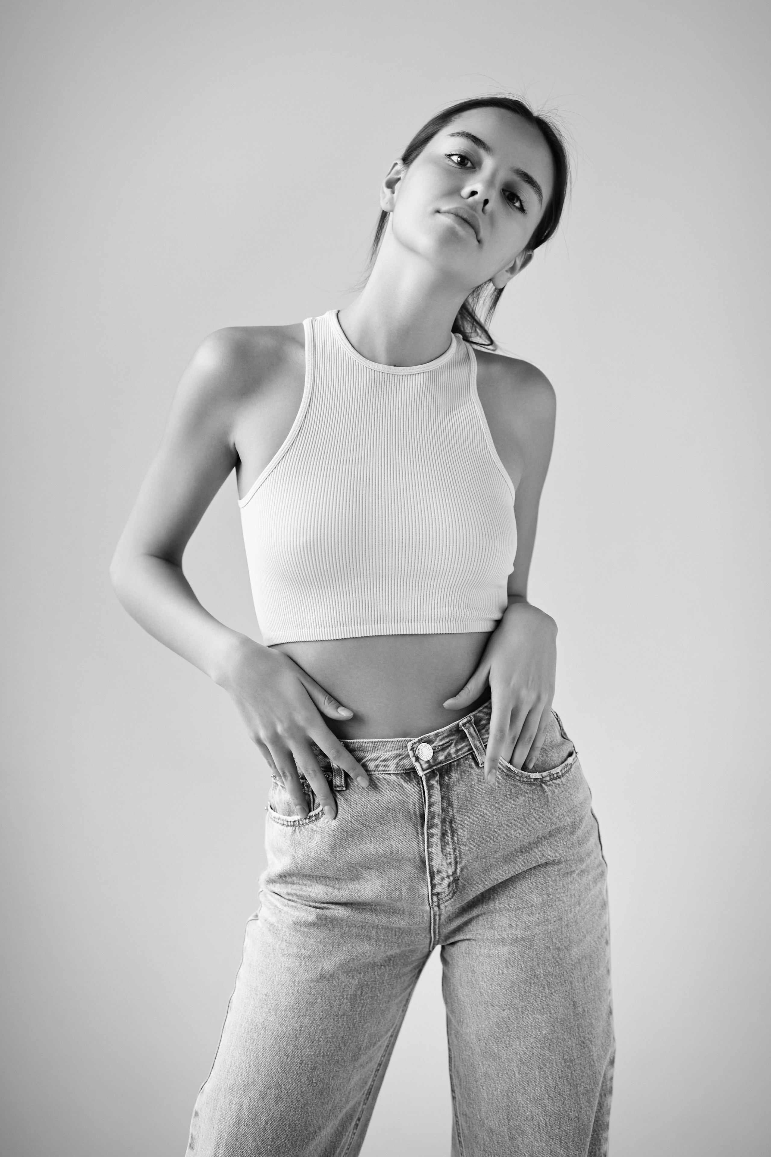 Чарующая красотка Амина в светлом наряде на фоне студии.