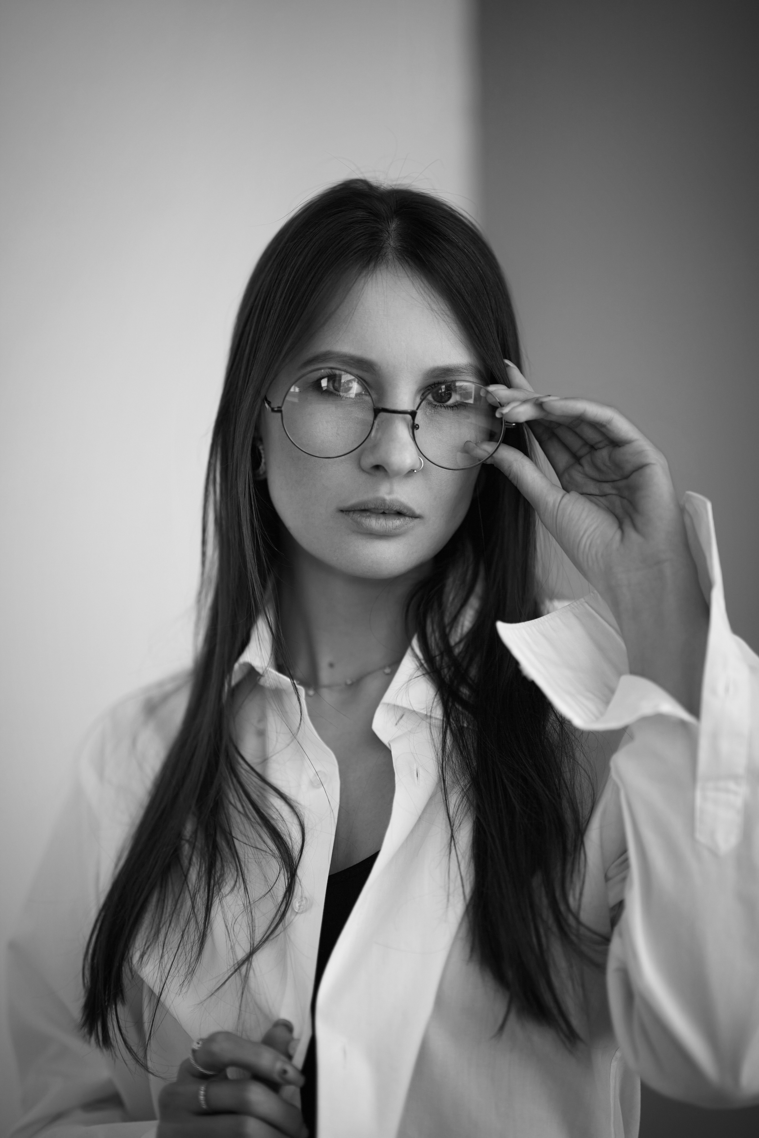 Девушка с темными волосами на циклораме с светлым фоном создаёт свой образ.