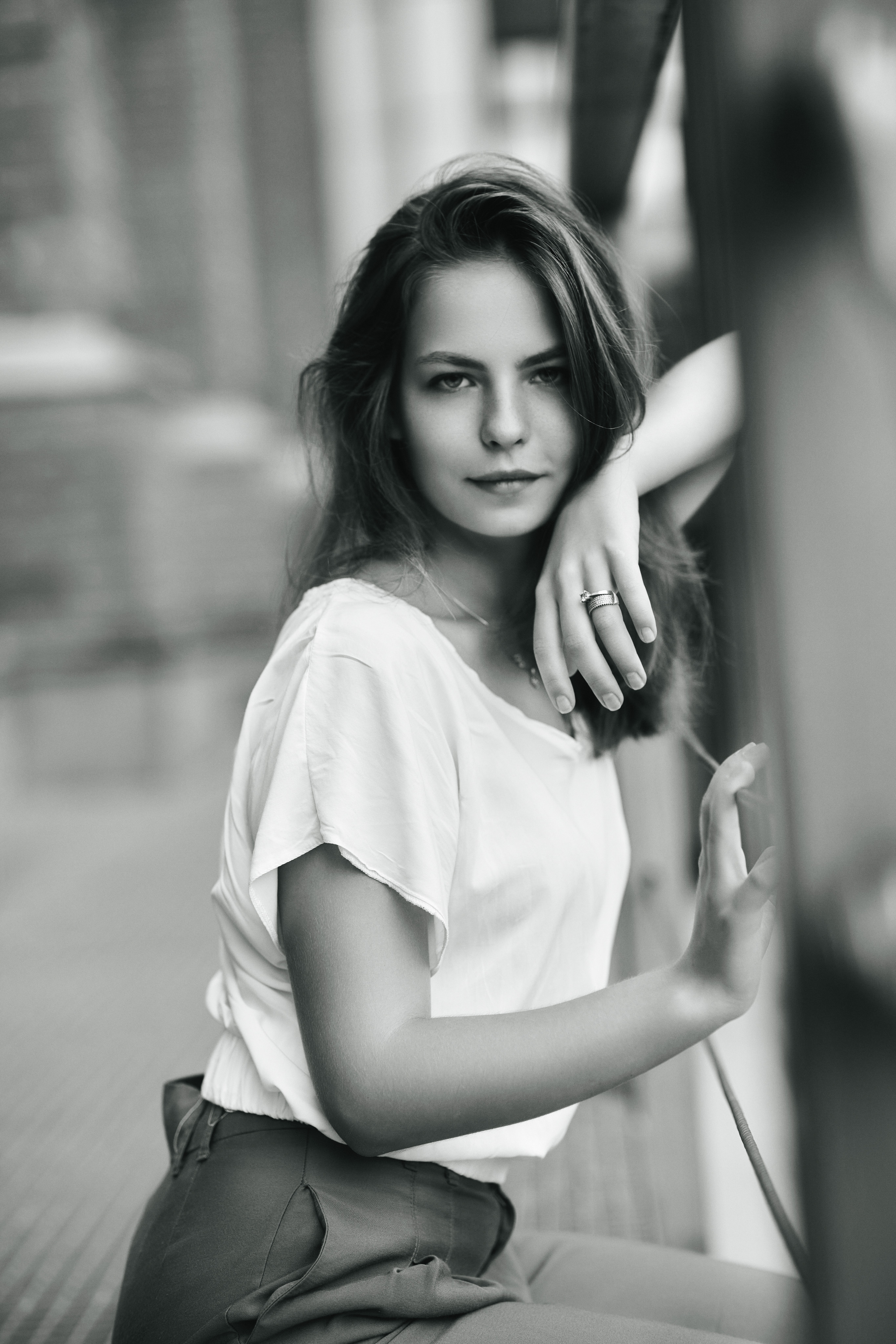 Темноволосая Дарья на улице Москвы в светлой кофте и широких брюках.