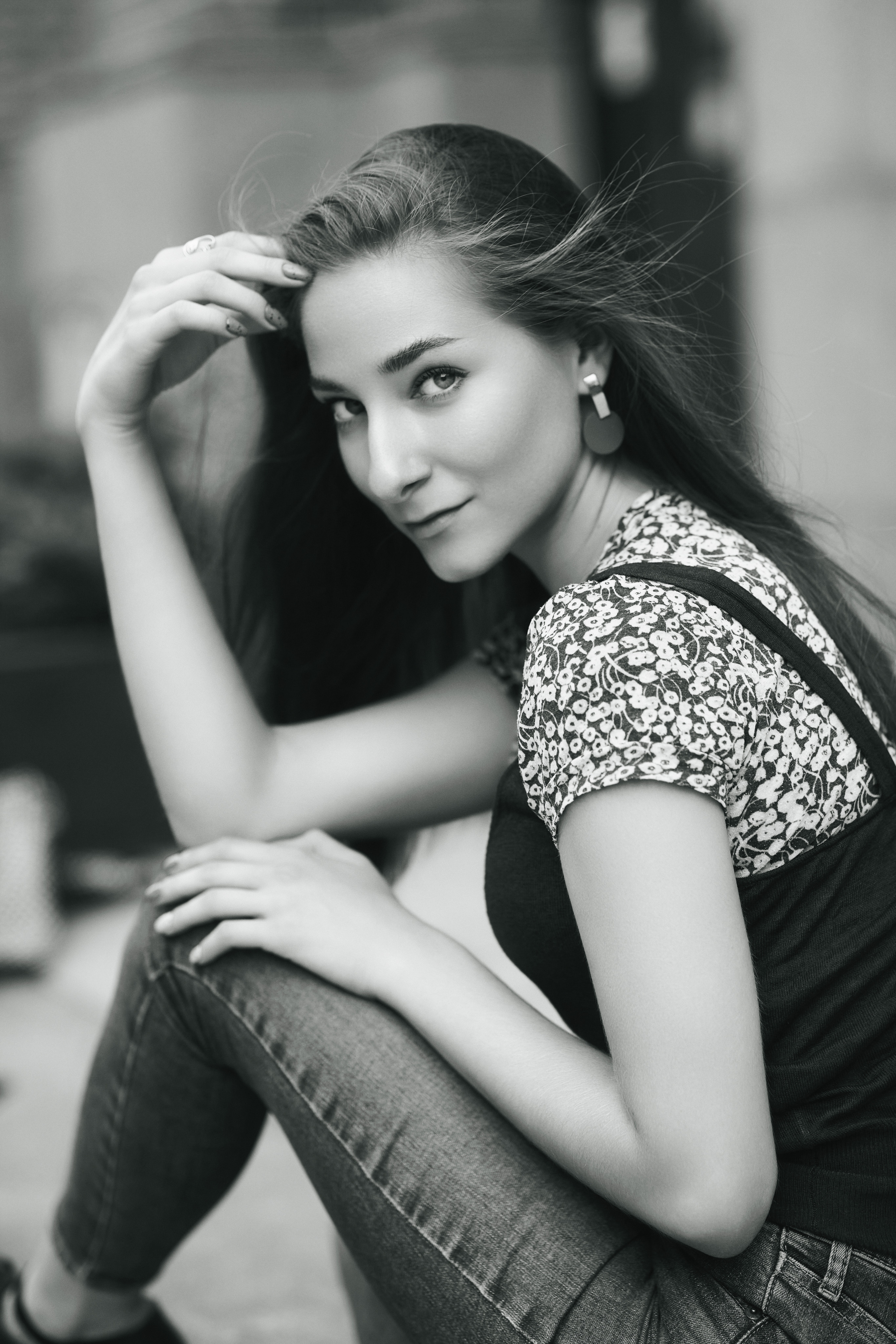 Любовь, модель с темными волосами, на фоне городских зданий в элегантном платье или удобных джинсах.