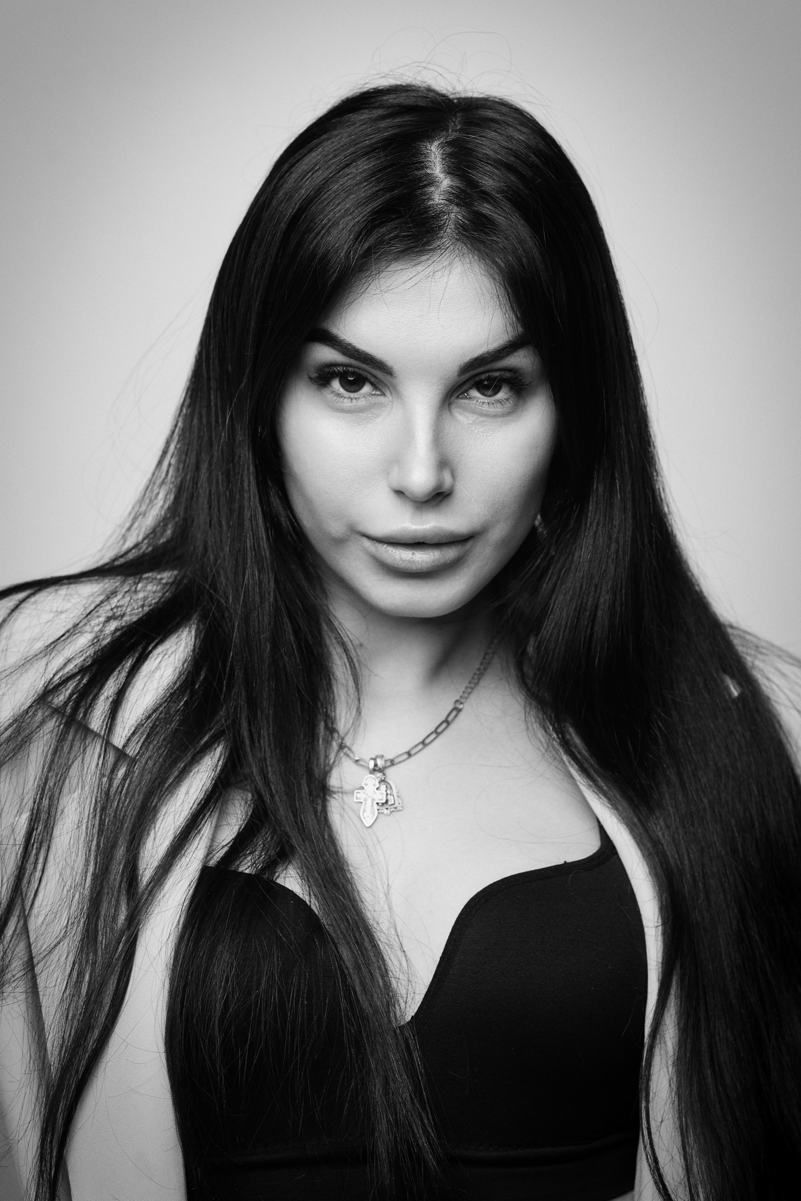 На светлом фоне студии темноволосая Карина в костюме создает образ руководителя, который всегда знает, что делать.