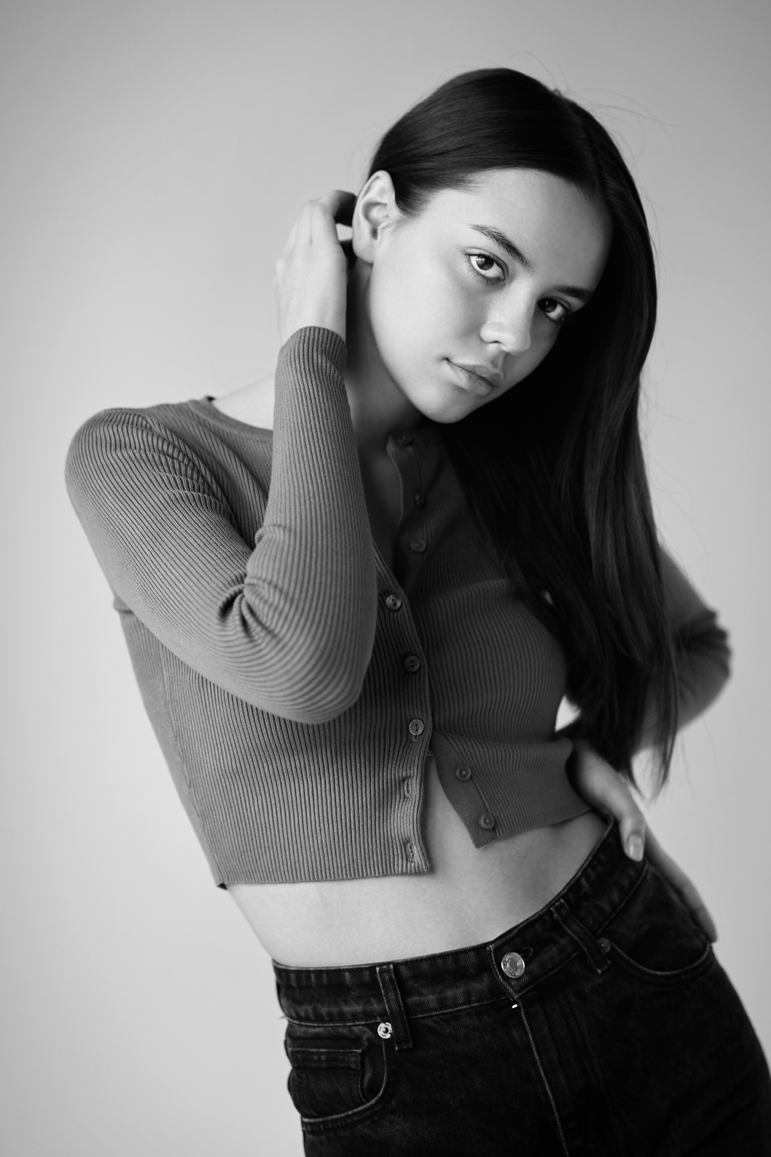 Модель Амина в светлых нарядах на фоне студии с элегантным образом.