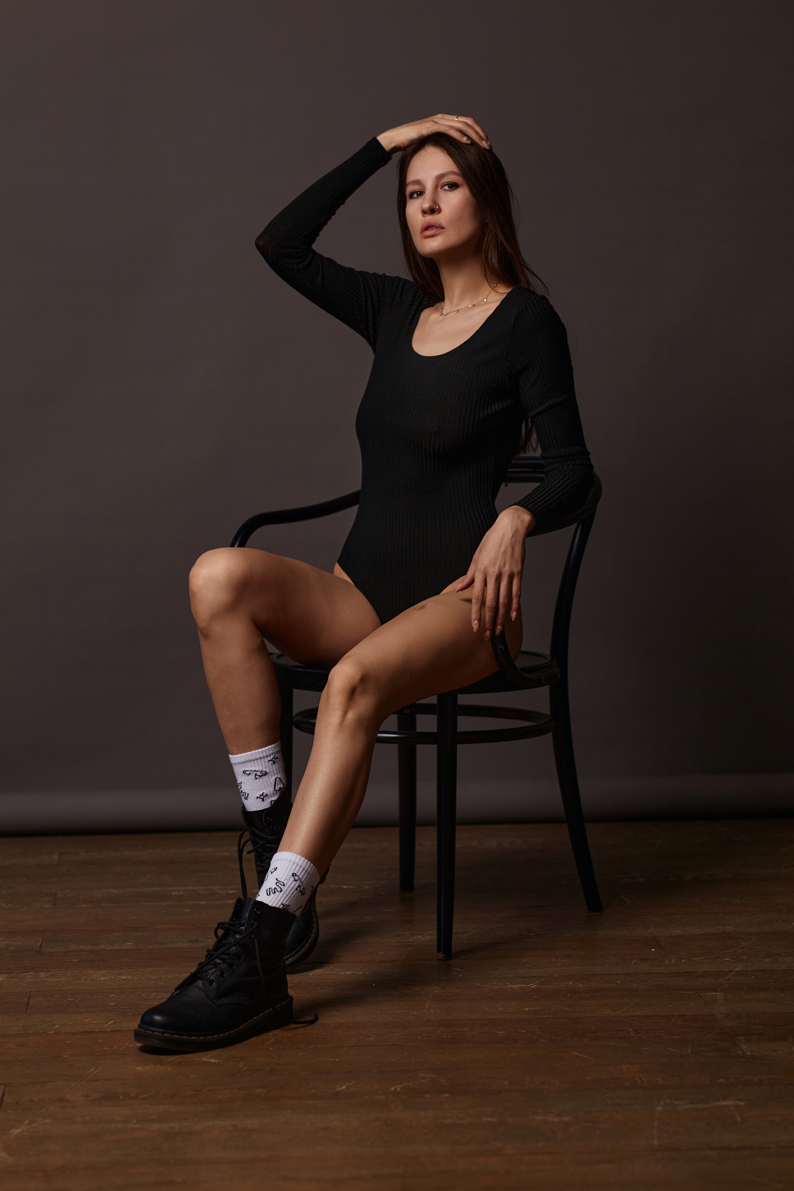 Темноволосая модель на светлой циклораме в студии.