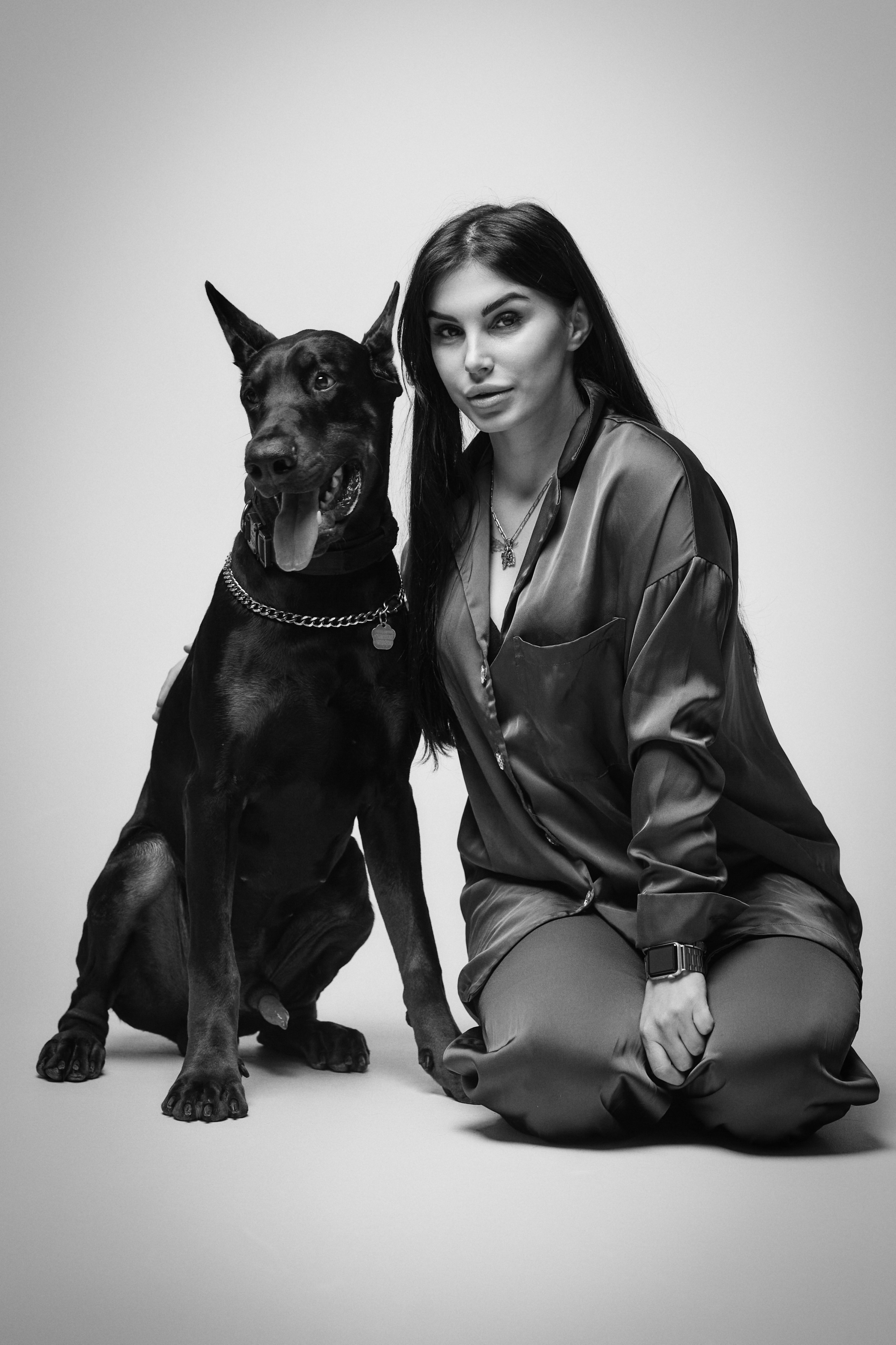 Карина выглядит превосходно в платье на светлом фоне в студии.