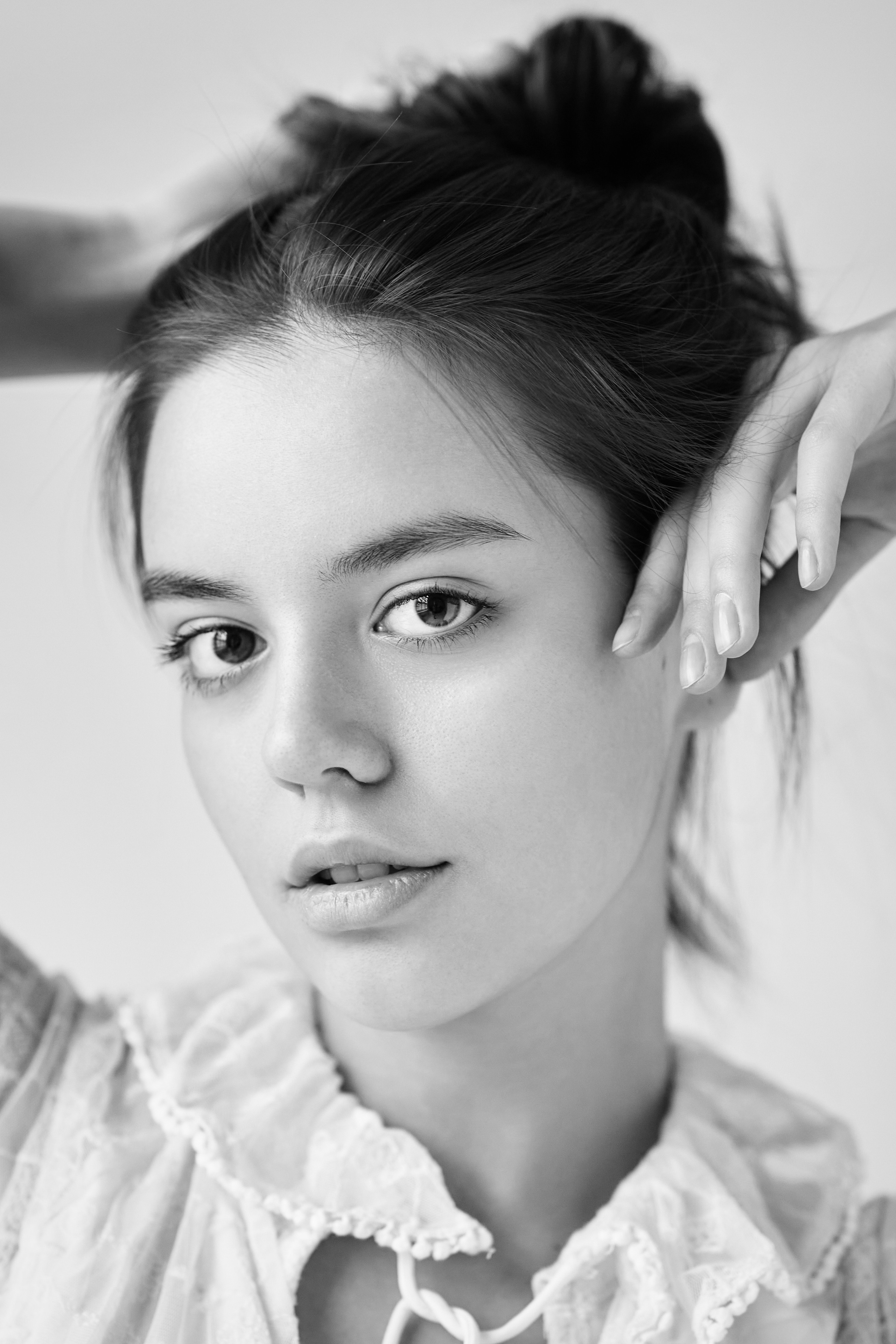 На светлом фоне темноволосая модель Амина в светлом платье выглядит изящно и утонченно.