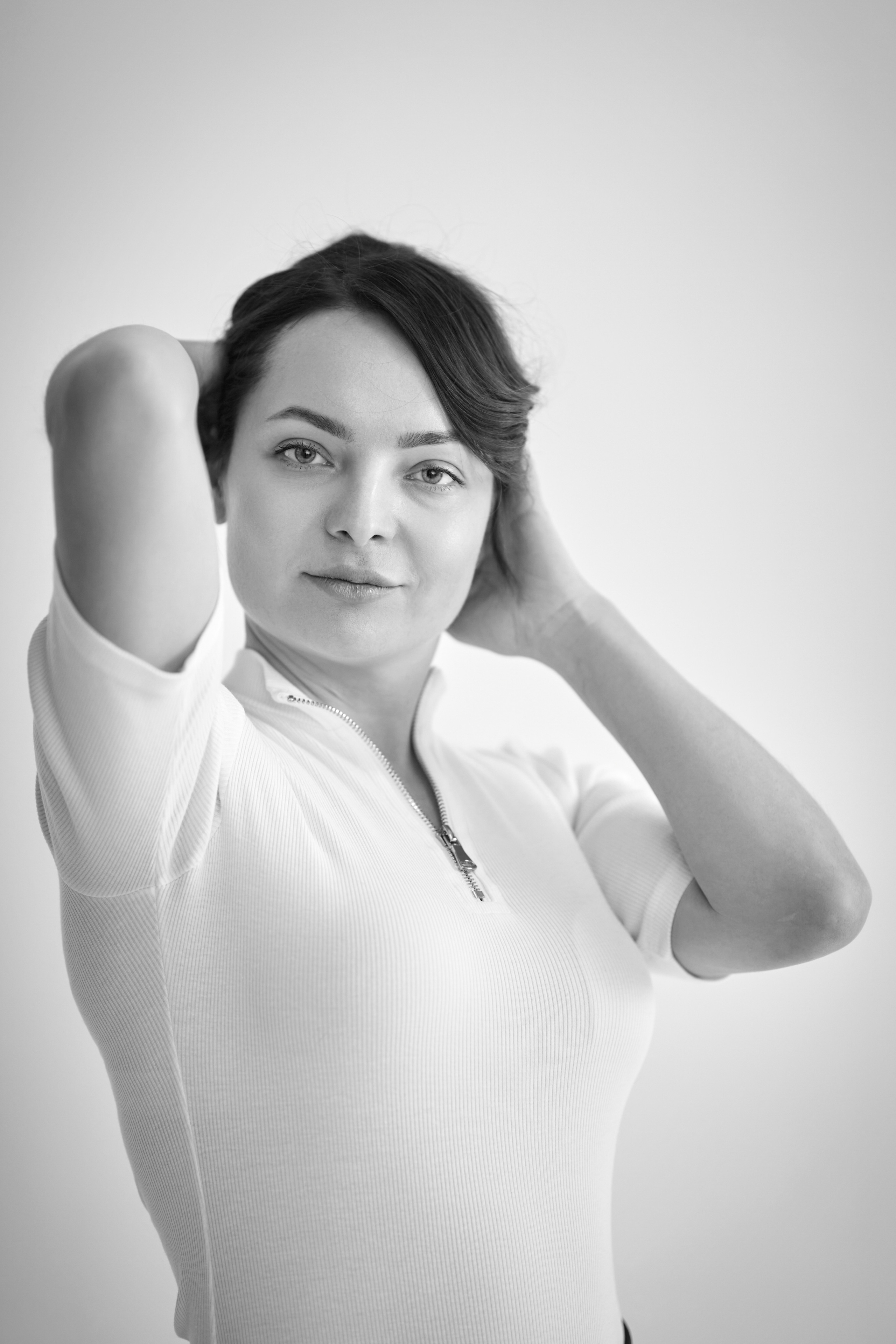 В студии на светлом фоне стоит Татьяна, модель, в светлом платье.