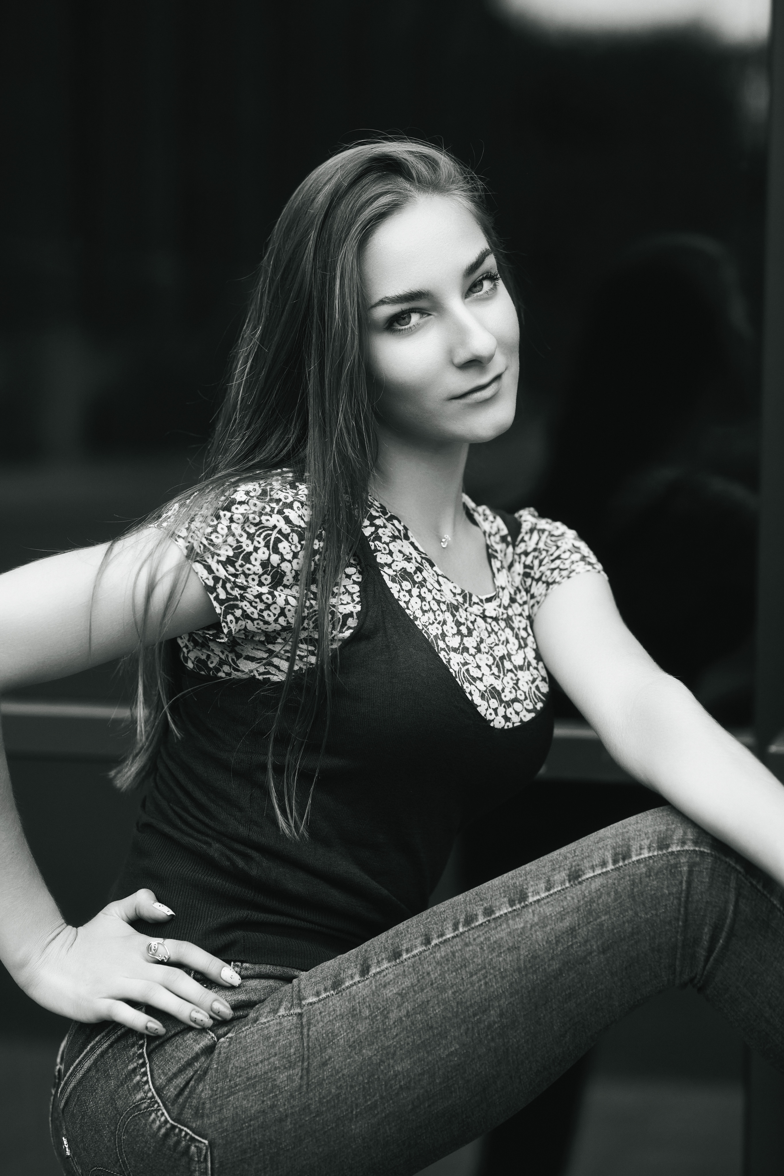 Фотография Любови, темноволосой модели на улице в городе, одетой в привлекательное платье или джинсы