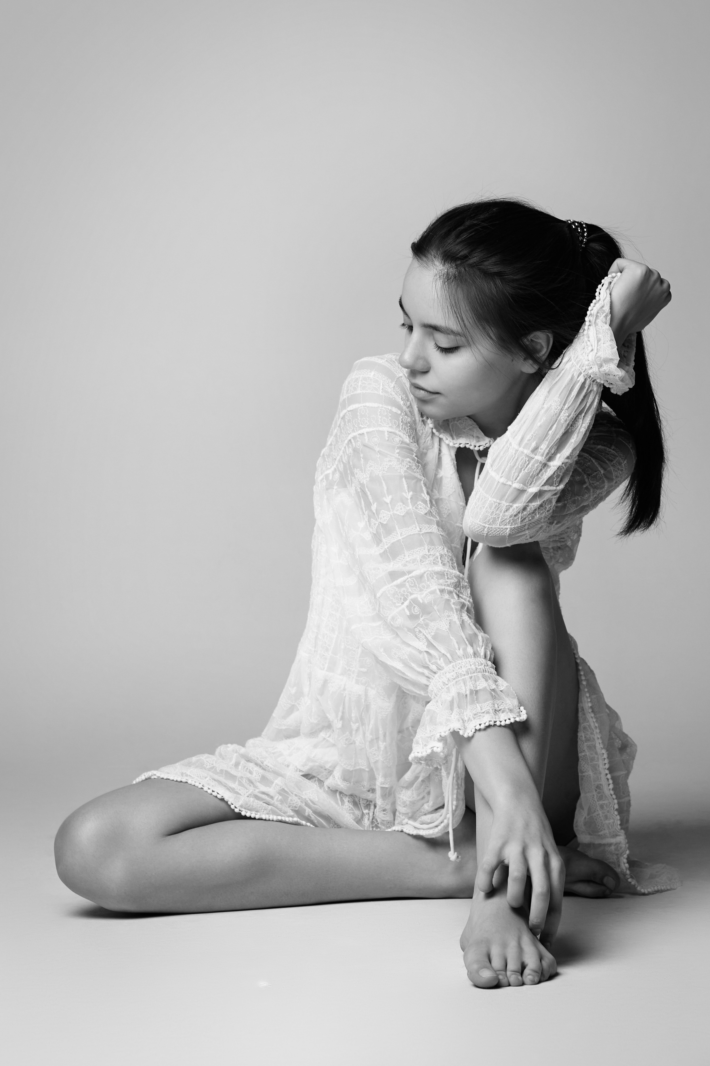 На светлом фоне темноволосая модель Амина в светлом платье выглядит невероятно красиво.