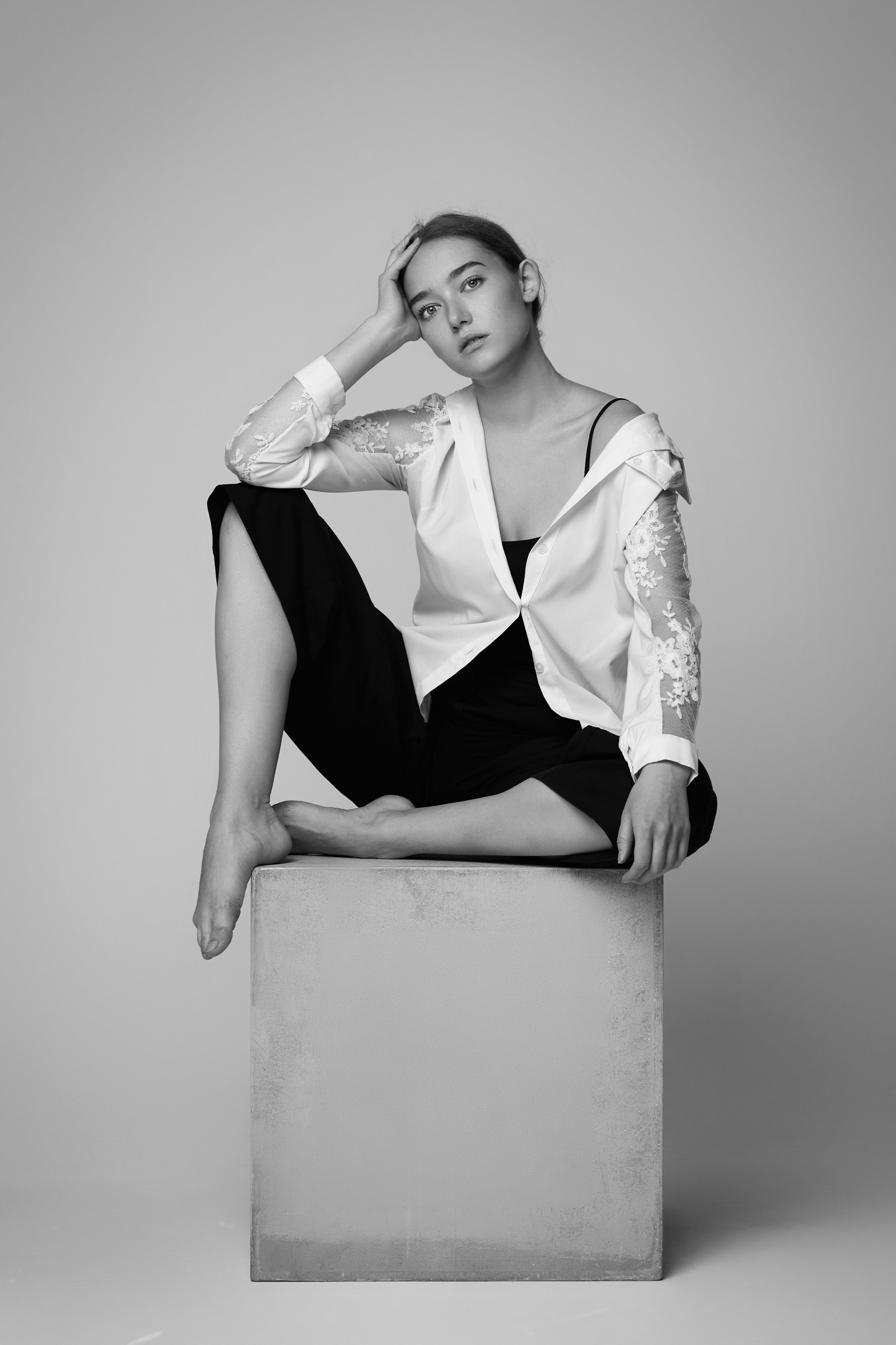 Алиса, модель с яркой внешностью, воплощает образ в студии на светлом фоне, одев платье или рубашку.