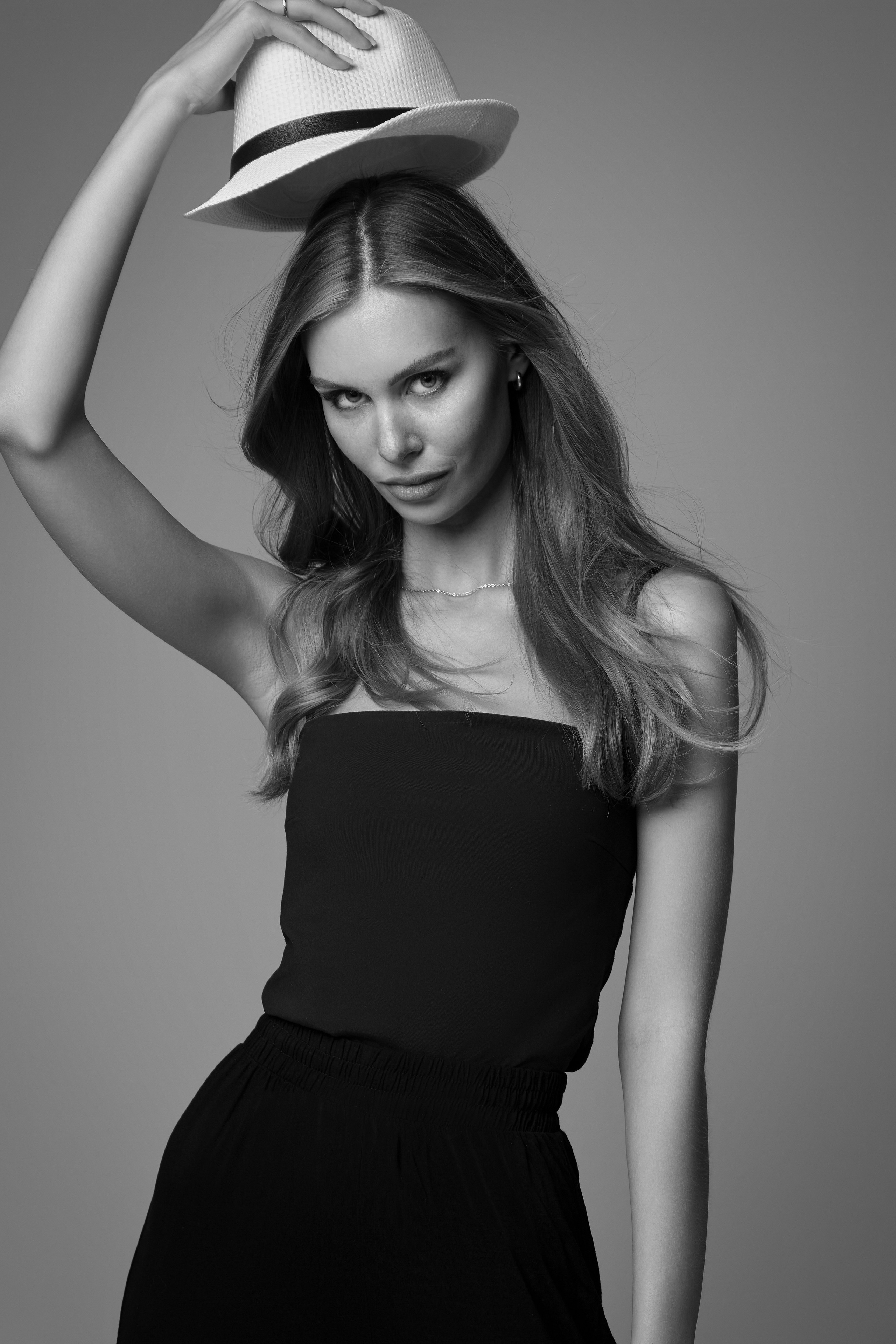 Девушка в очках на светлом фоне фотоателье.