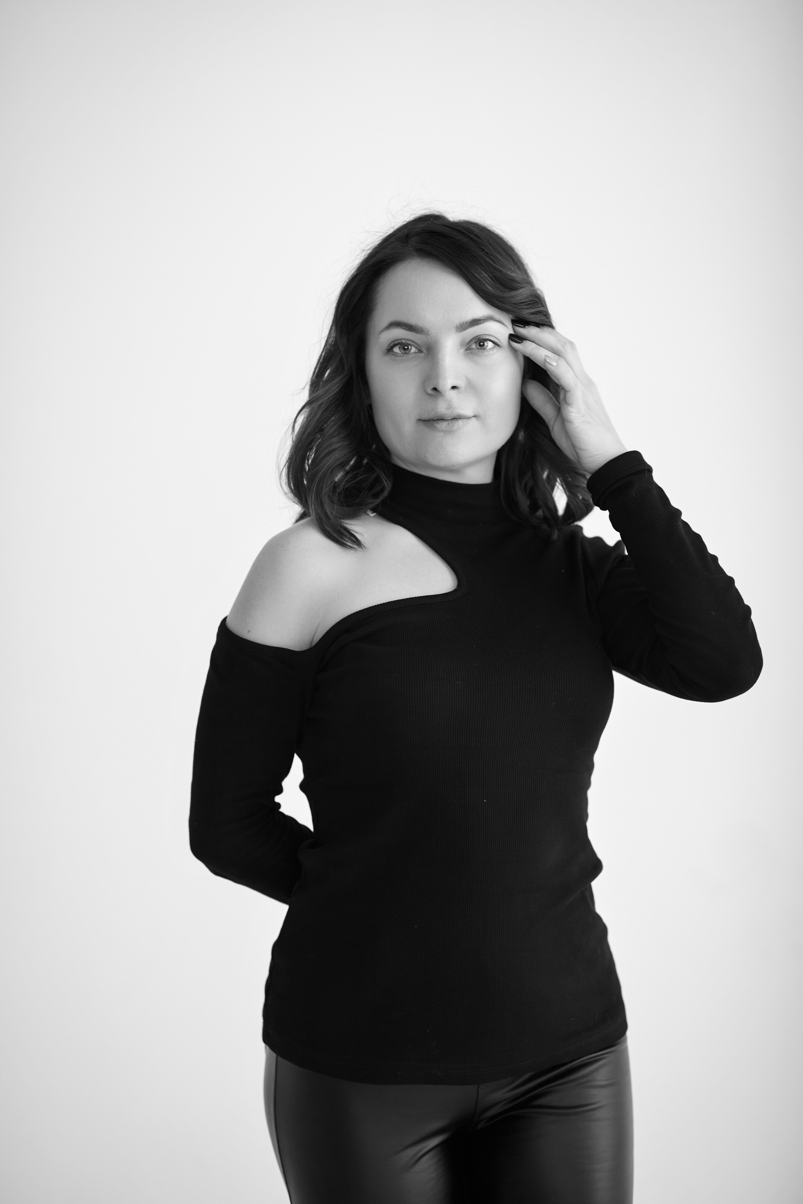 Снимок темноволосой модели Татьяны в студии на светлом фоне в светлом платье, рубашке или топике или на стуле.