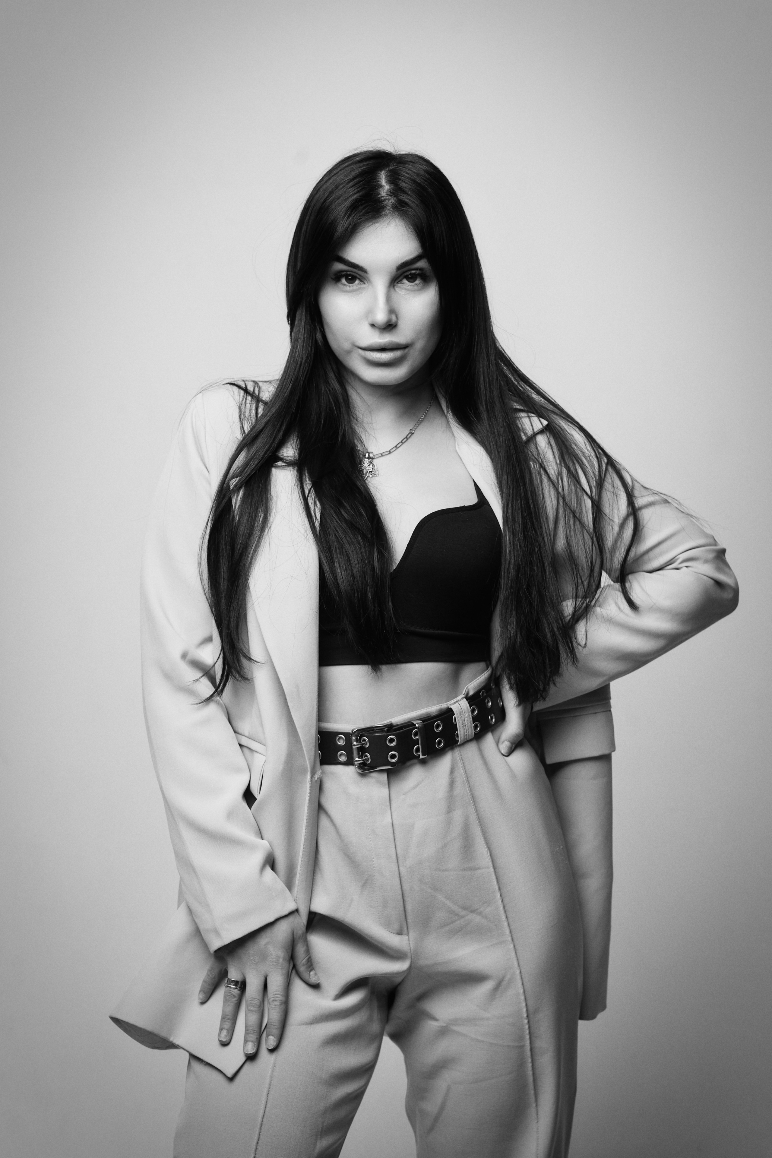 Темноволосая модель Карина в рубашке на светлом фоне студии создает образ легкой непринужденности и свободы.