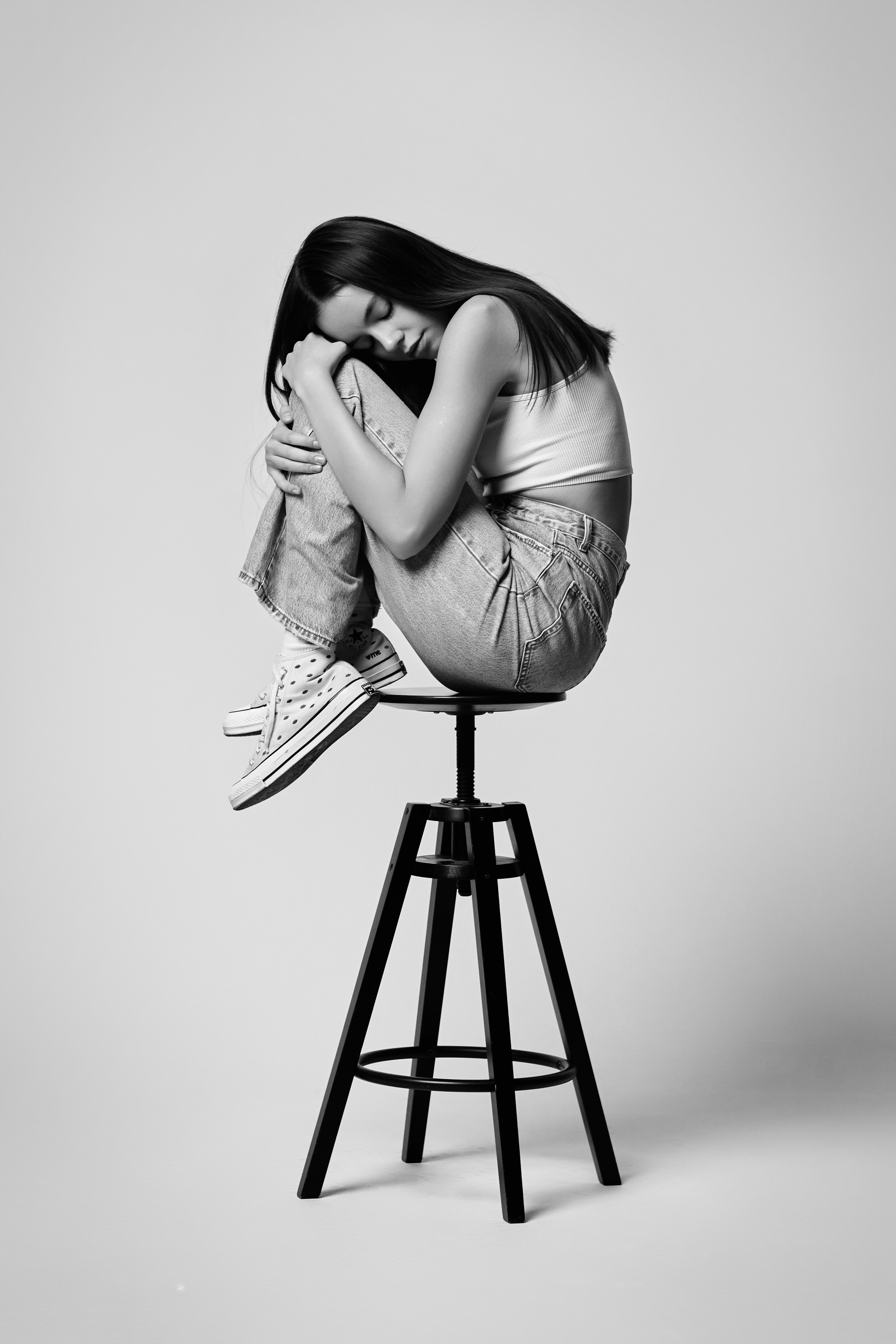 Амина в светлых нарядах на фоне студии.