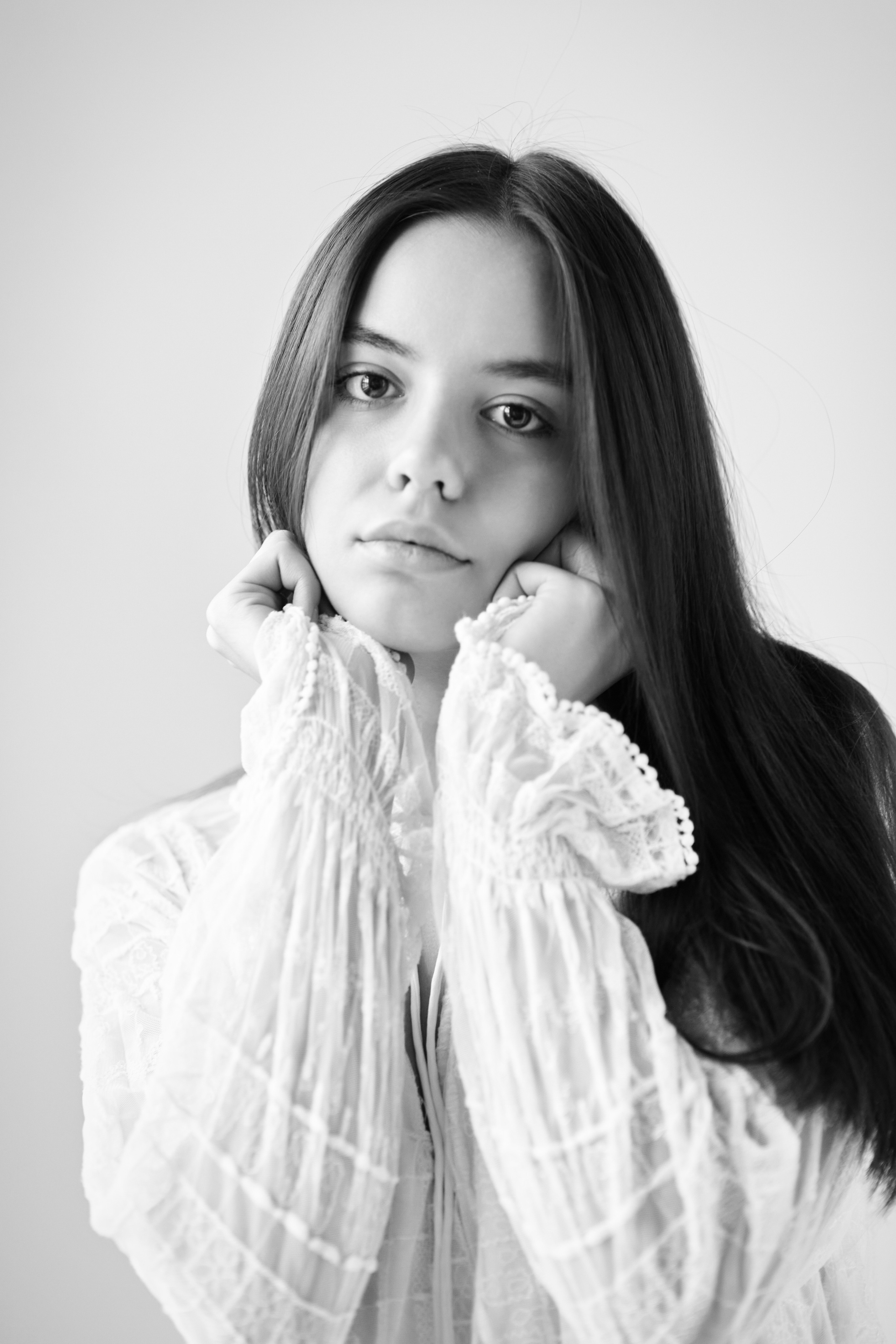 В рубашке на светлом фоне темноволосая модель Амина выглядит стильно и уверенно.