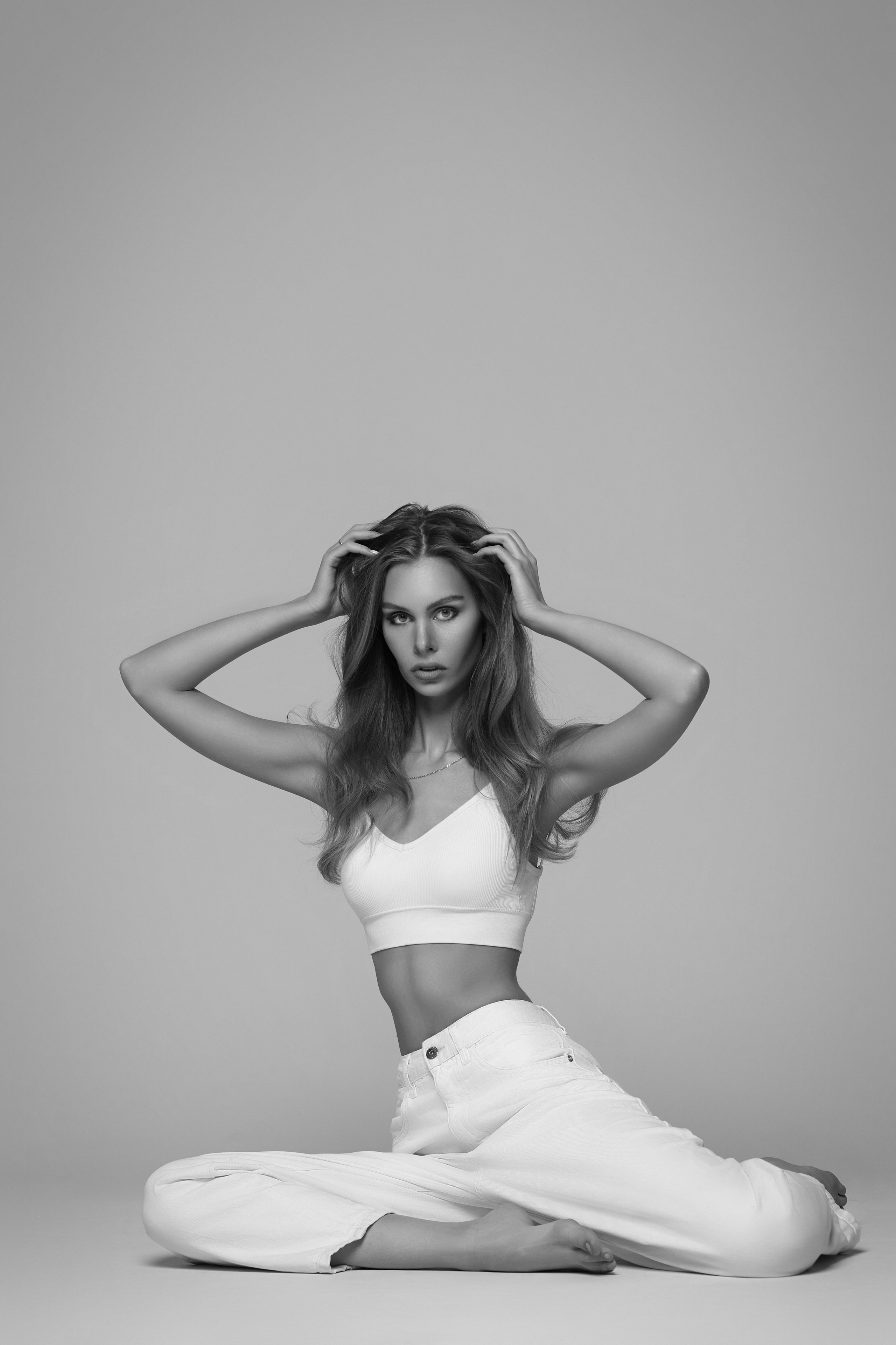 Темноволосая девушка в шляпе и очках на светлом фоне - образ стильной леди.