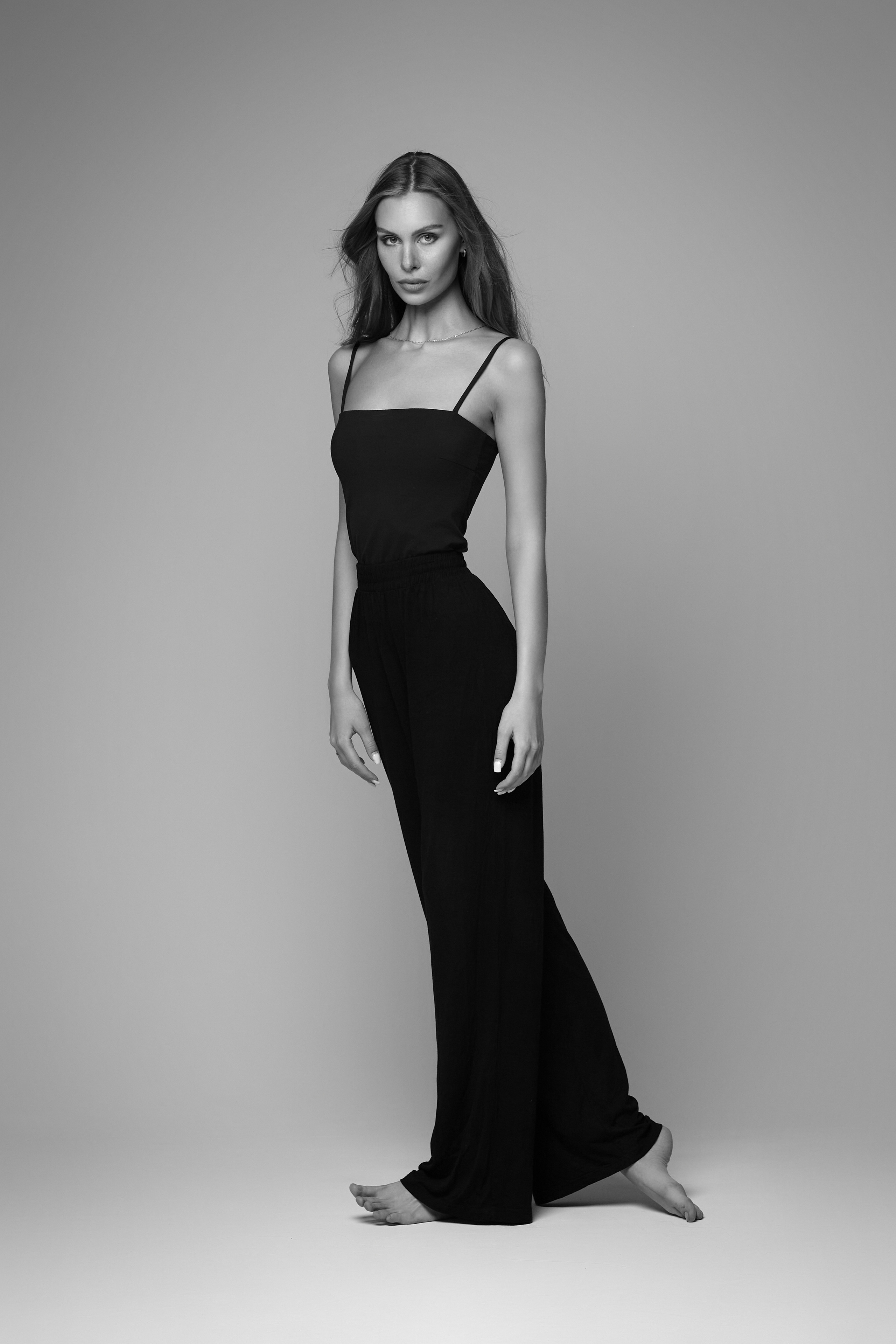 Темноволосая девушка в шляпе и очках на светлом фоне - яркий образ для модного журнала.