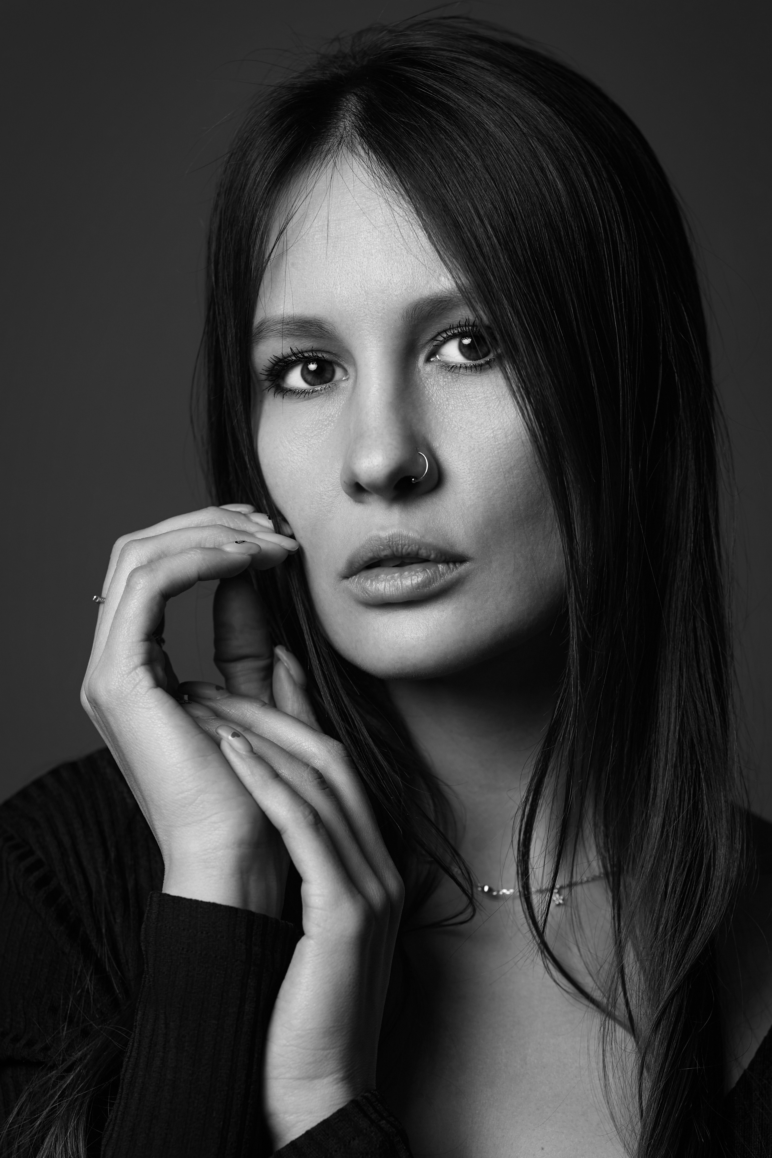 Темноволосая красотка на светлой циклораме в студии.