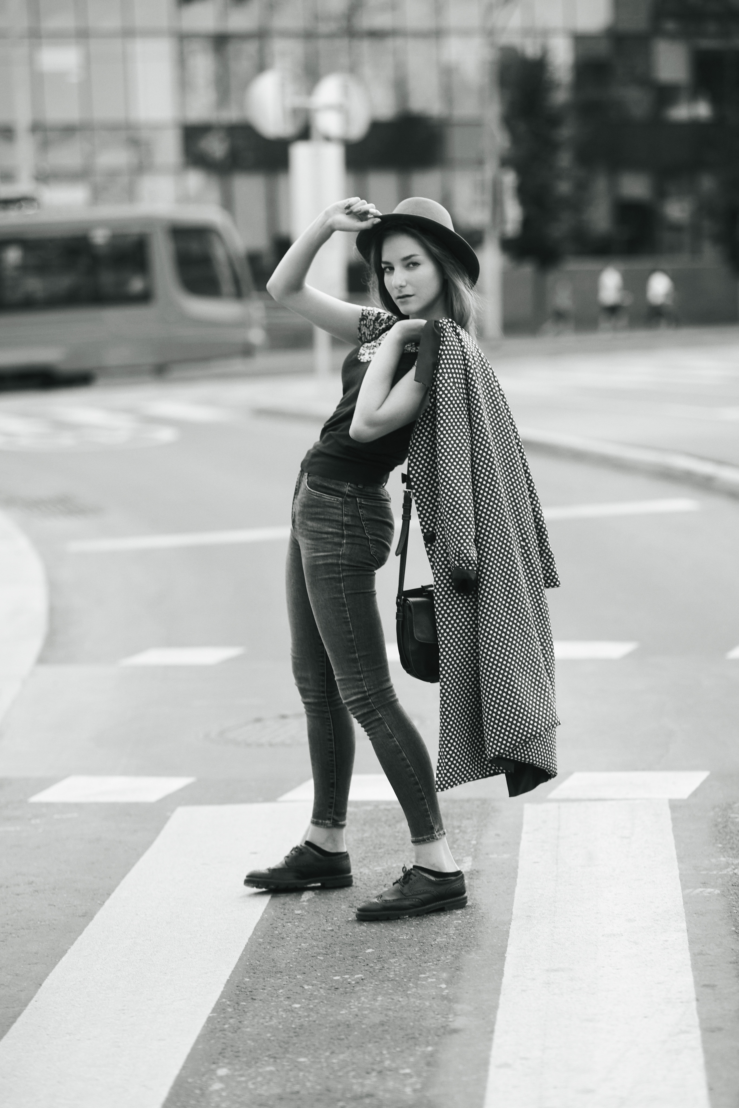 Темноволосая модель Любовь, на фоне городского пейзажа в красивом платье или комфортных джинсах.