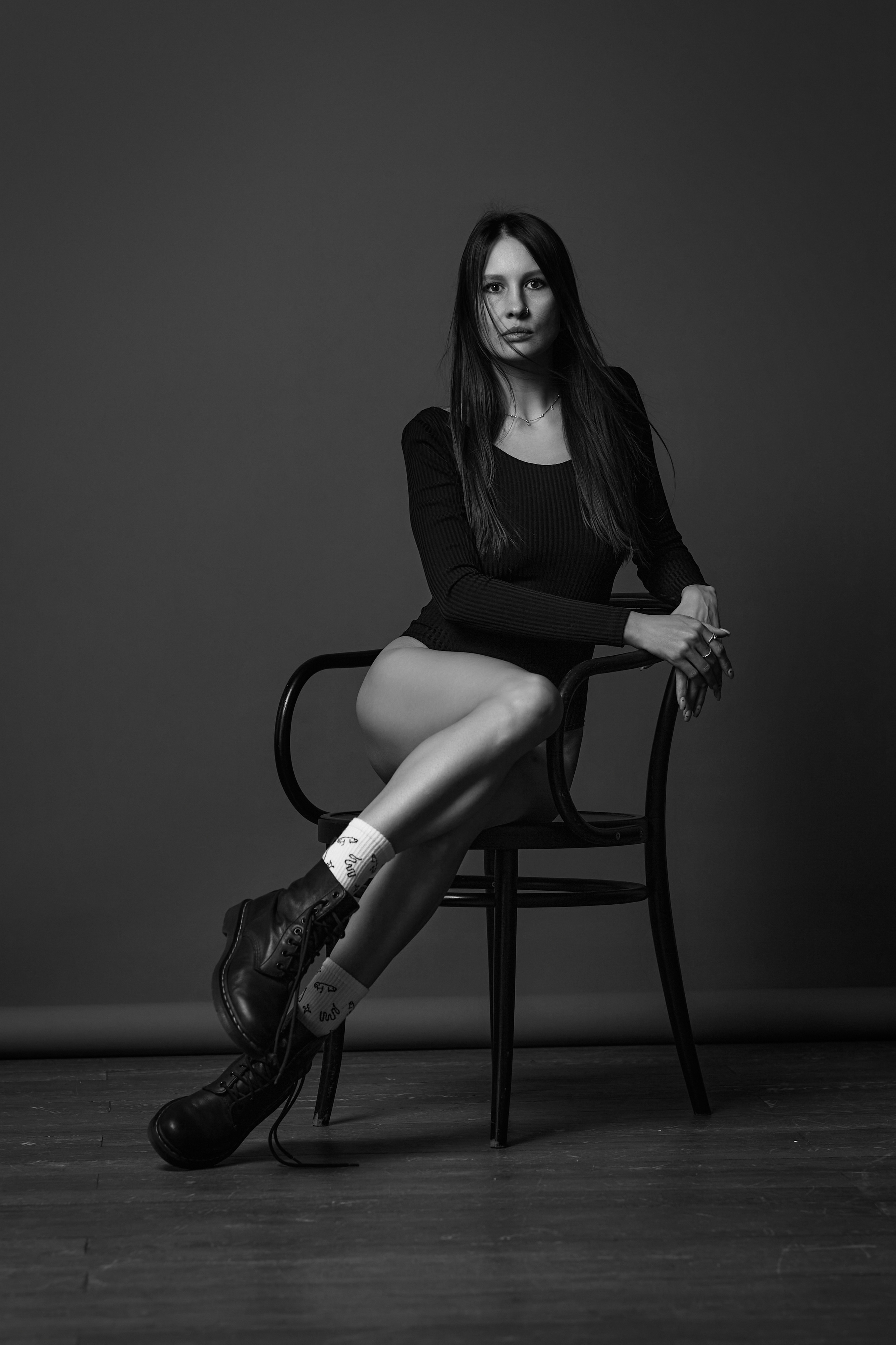 Девушка на темном циклорамном фоне в студии.