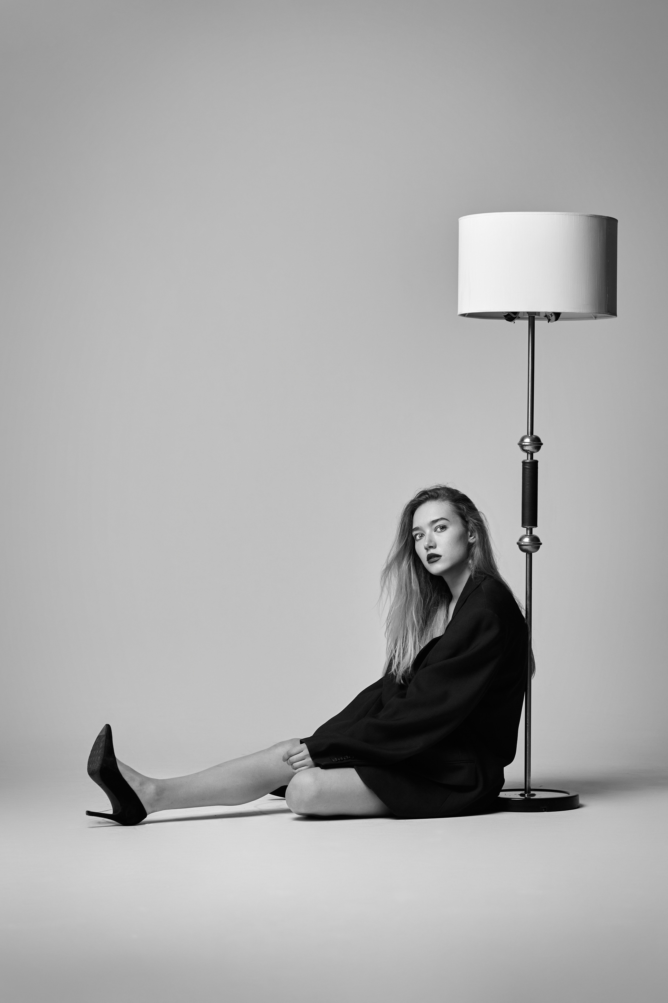 Стильная светловолосая модель Алиса позирует в рубашке на светлом фоне фотостудии.