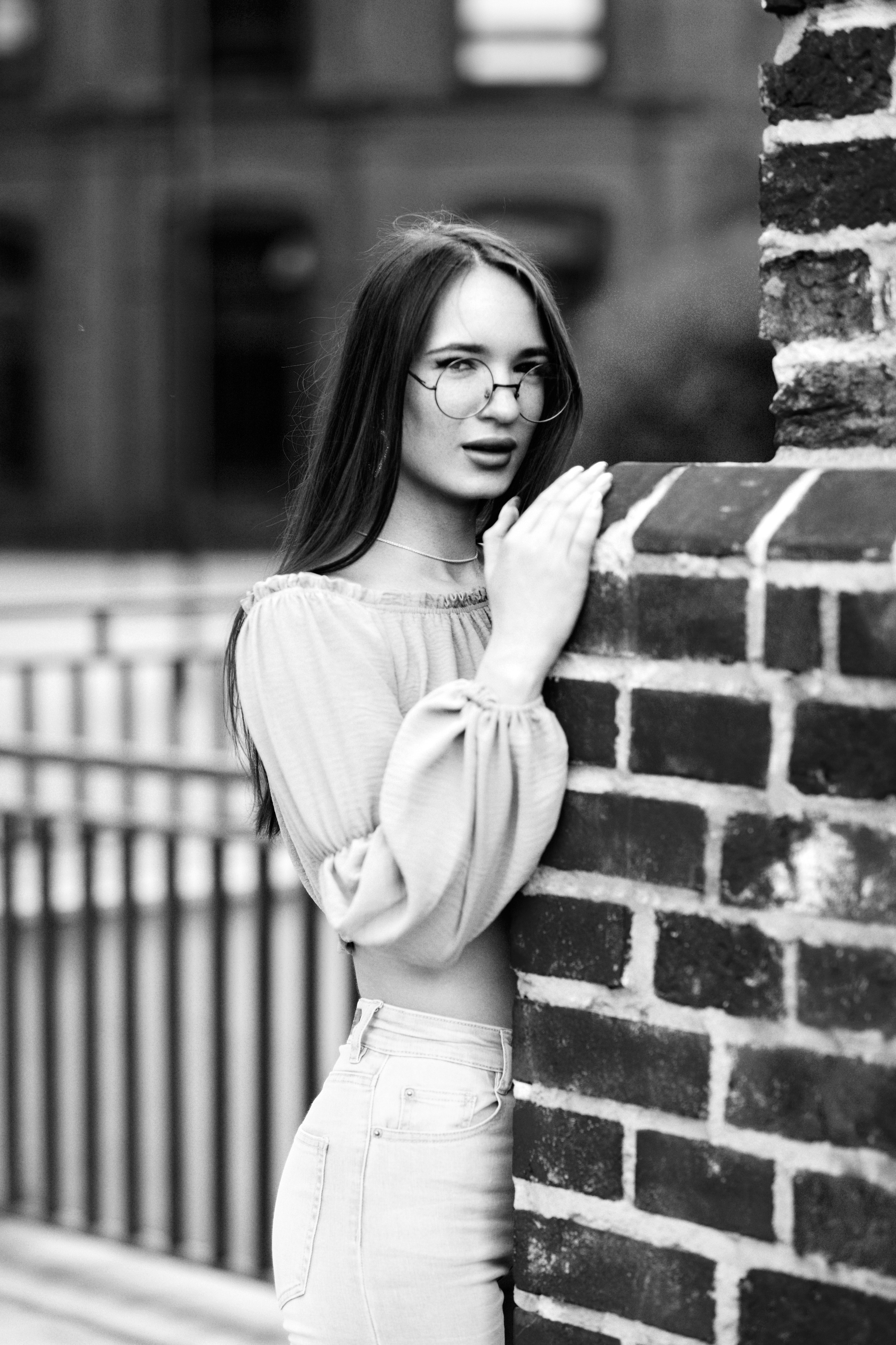 Молодая темноволосая девушка Маша на улице в центре города в элегантном платье или джинсах.