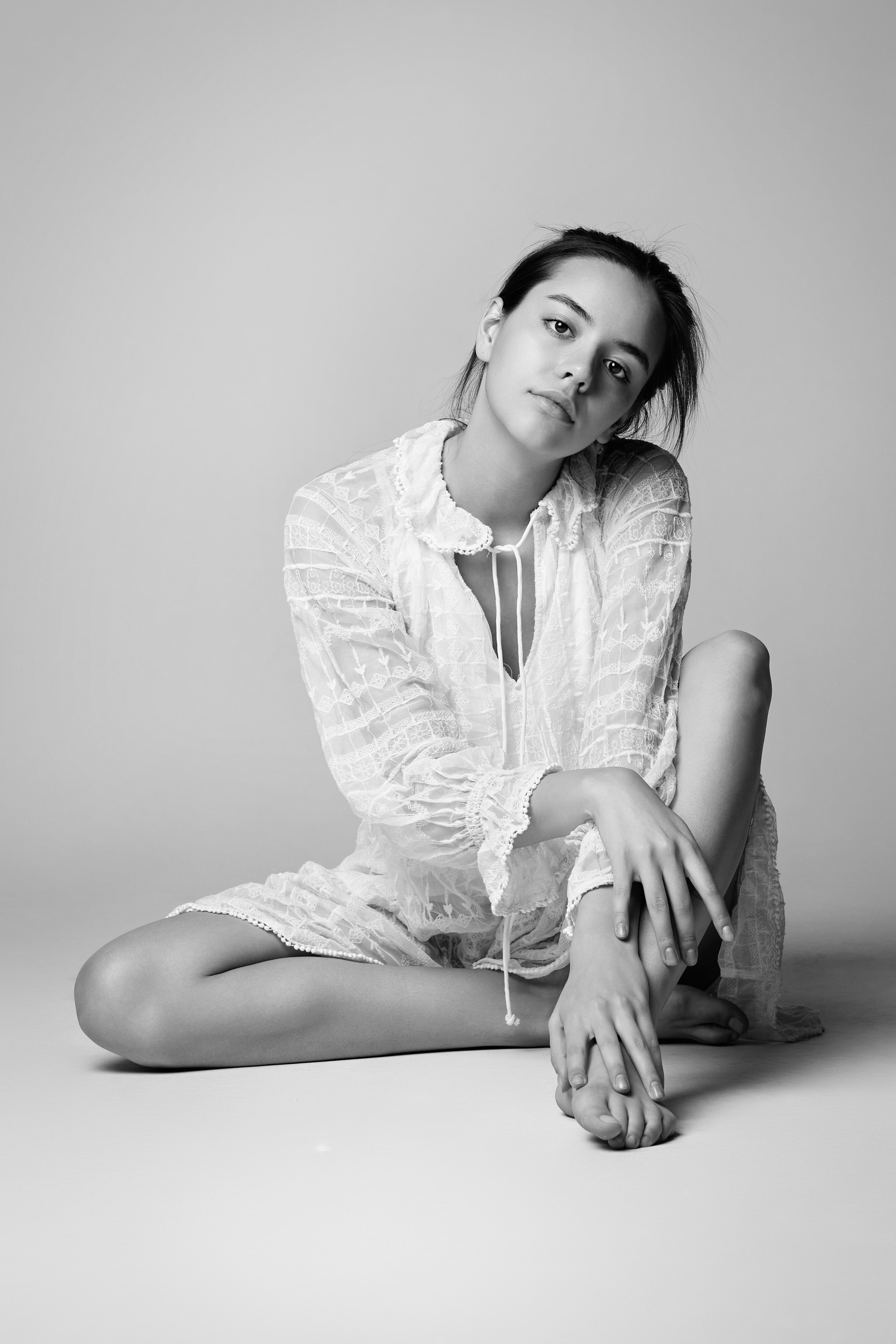 В студии на светлом фоне красивая модель Амина в светлом топике