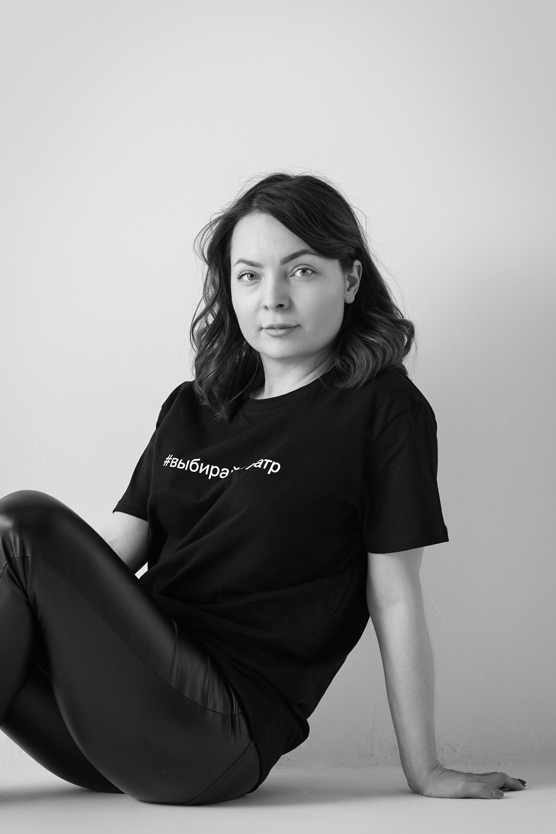 Модель Татьяна в светлом платье стоит на светлом фоне в студии.